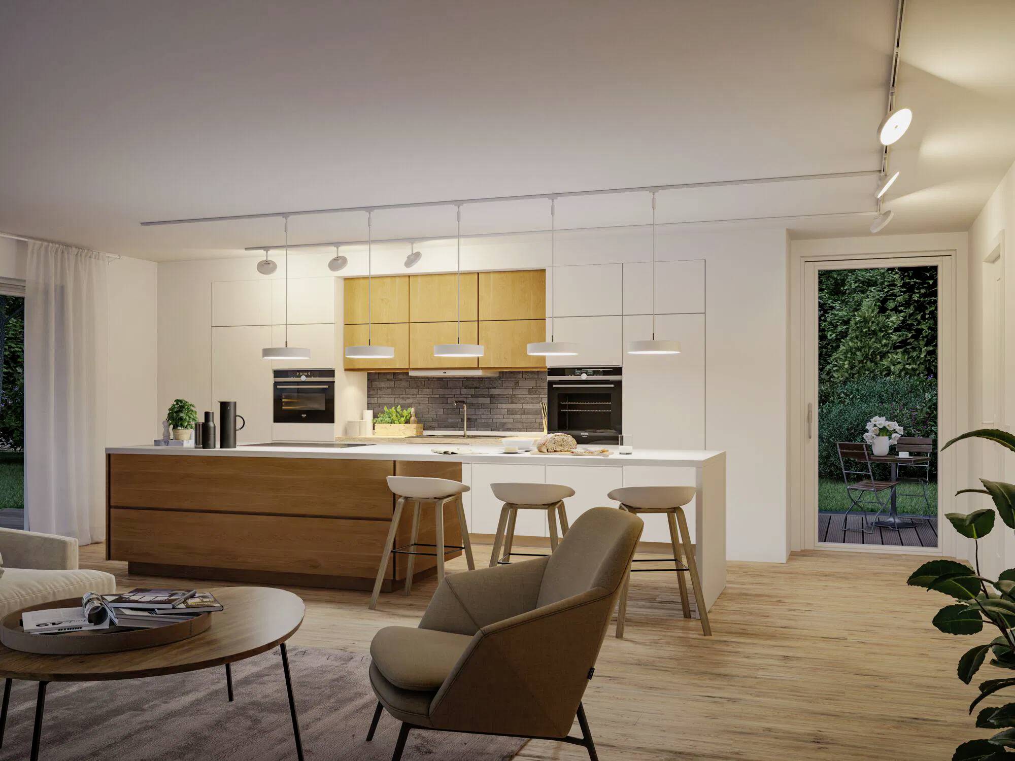 Eine moderne Küche und Essbereich mit Holzschränken, einer zentralen Kücheninsel mit Barhocker und einer sichtbaren Terrassentür, die in einen Garten führt.