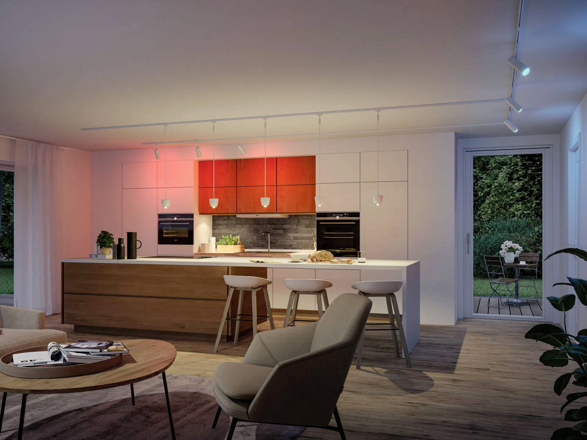 Eine moderne Küche mit intelligenter Beleuchtung; das puristische Design umfasst eine Insel mit Barhockern, Pendelleuchten und großen Fenstern, die einen Garten offenbaren.