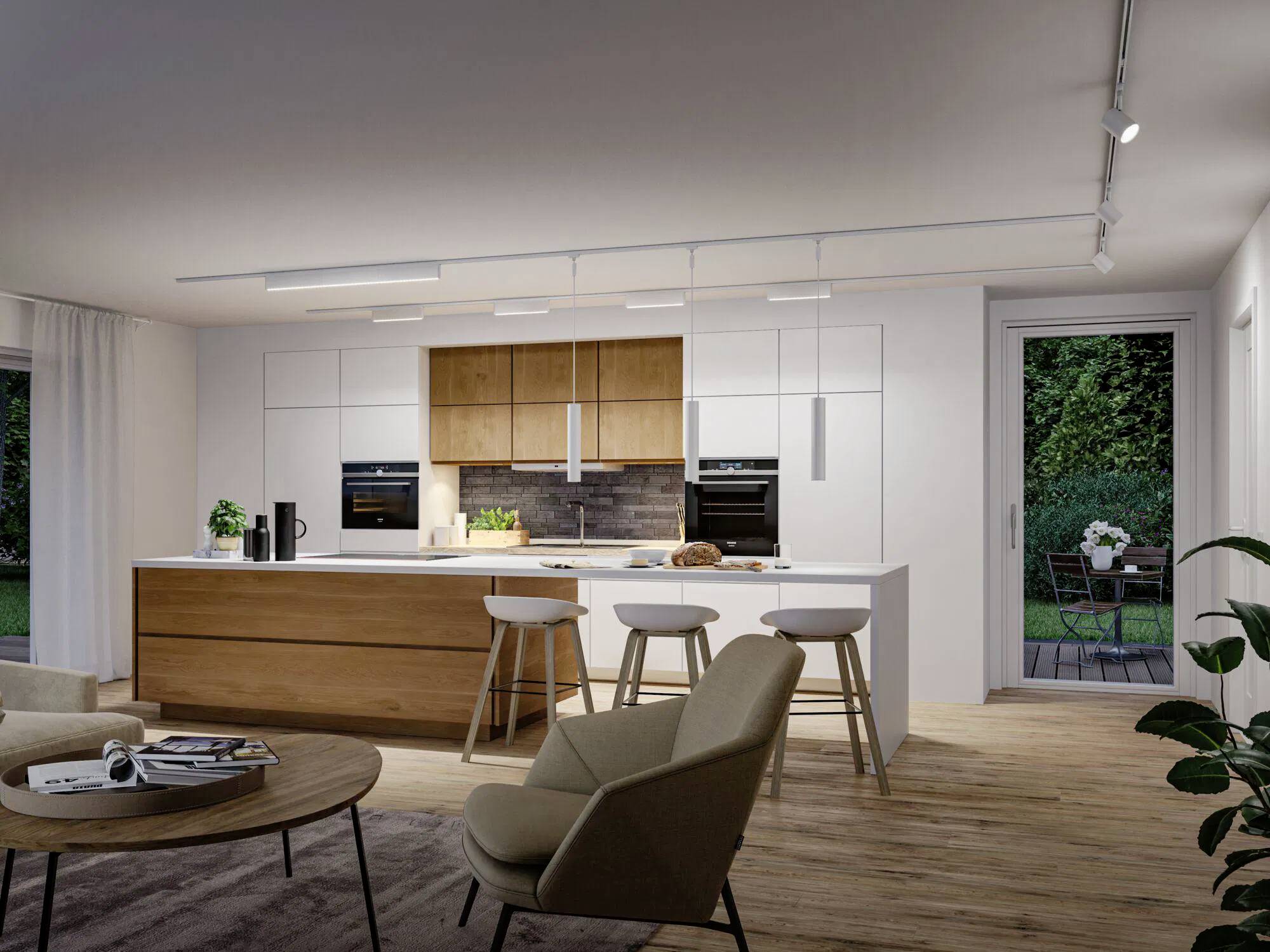 Eine moderne Küche mit einer großen Holzinsel, weißen Schränken, eingebauten Öfen und Barhockern. Eine Terrasse ist durch Glastüren zu sehen.