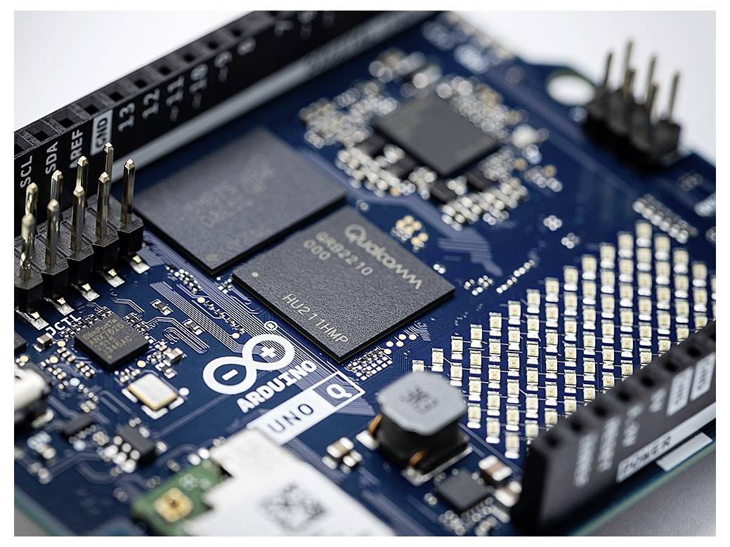 Eine Nahaufnahme einer Arduino-Leiterplatte, die verschiedene elektronische Komponenten und Verbindungen hervorhebt, einschließlich Pins und eines Mikrochips.