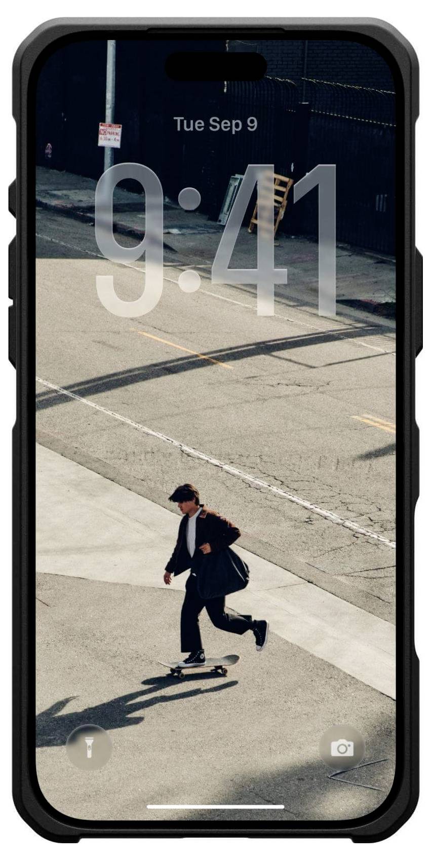 Eine Person fährt auf einem Skateboard eine urbane Straße entlang, trägt einen Anzug und trägt eine Umhängetasche. Ein Telefon-Sperrbildschirm zeigt die Uhrzeit '9:41'.