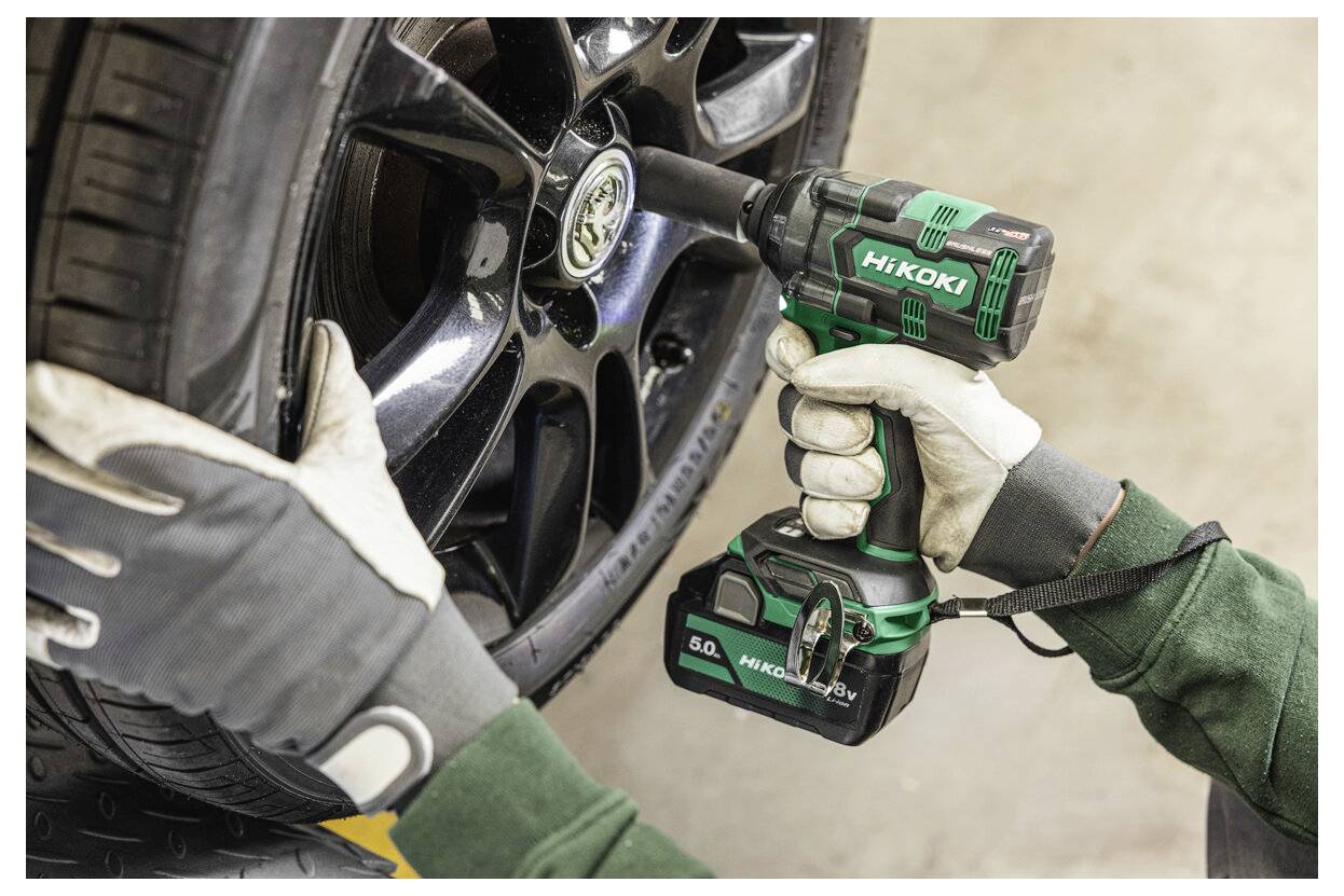 Ein Mensch verwendet einen kabellosen Schlagschrauber, um eine Radmutter an einem Auto festzuziehen und demonstriert dabei die einfache Handhabung und Effektivität bei der Automobilwartung.