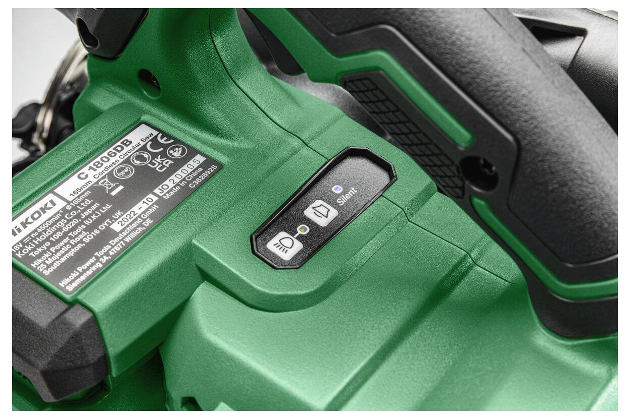 Nahaufnahme eines grünen Werkzeugs mit Bedienknöpfen, einem Herstelleretikett mit Beschriftung und einem strukturierten Griffbereich.