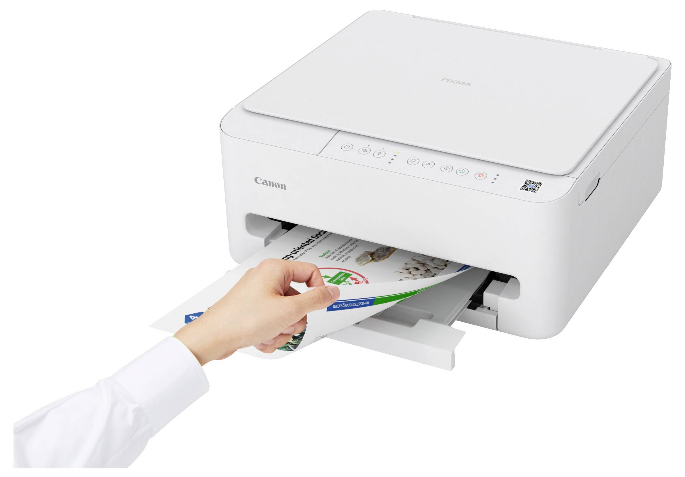 Eine Person nimmt gedruckte Blätter aus einem weißen Canon-Drucker auf einem Schreibtisch.