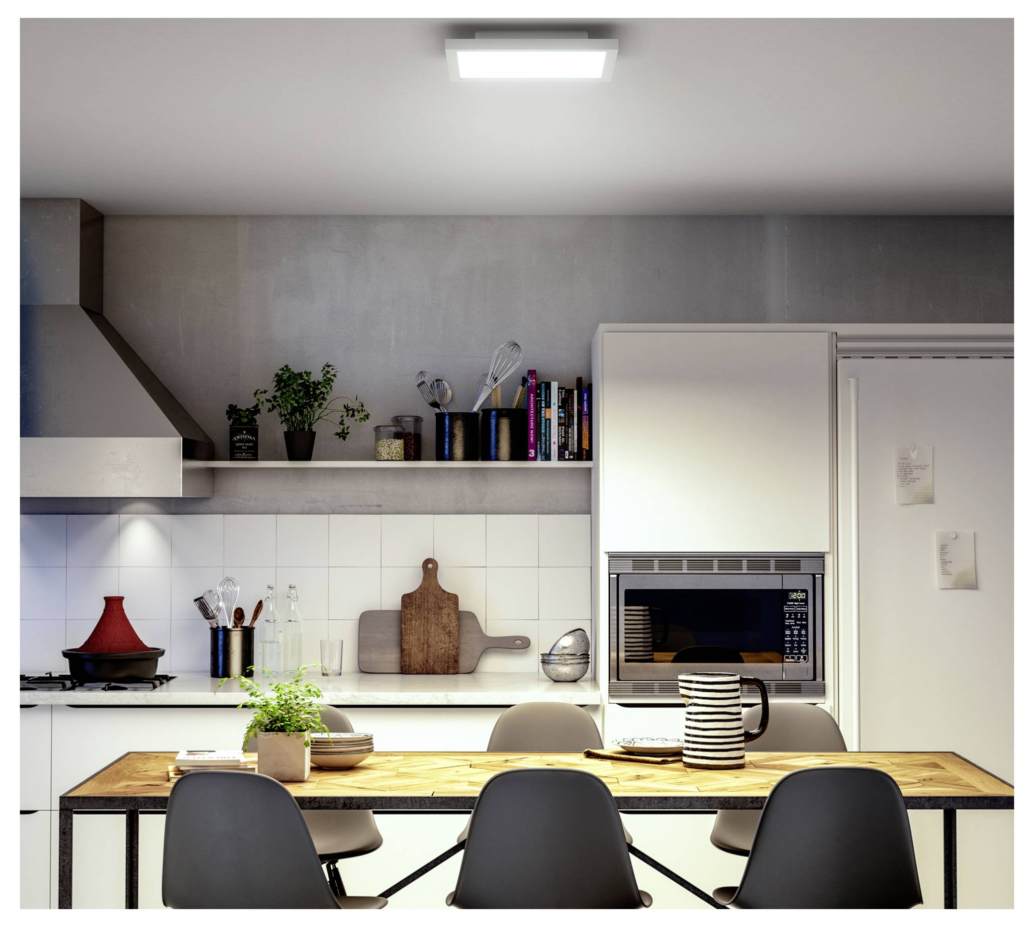 Eine moderne Küche mit einem Holz-Esstisch, der für vier Personen gedeckt ist. Regale tragen Pflanzen und Küchenutensilien. Ein Ofen ist in weiße Schränke eingebaut.