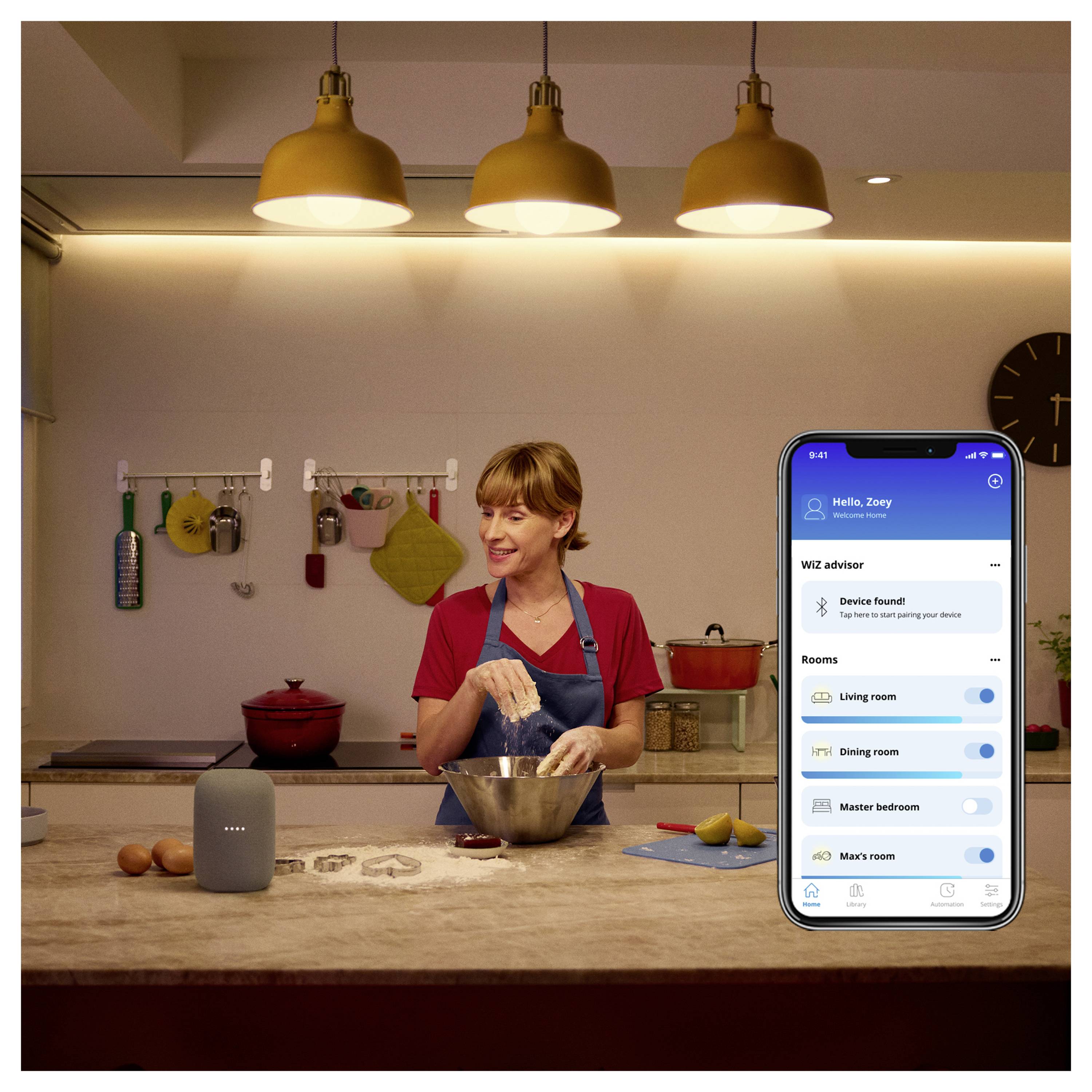 Eine Frau kocht in einer Küche und interagiert dabei mit einem Smart-Home-Gerät. Eine Smartphone-App-Oberfläche zeigt vernetzte Raumsteuerungen.