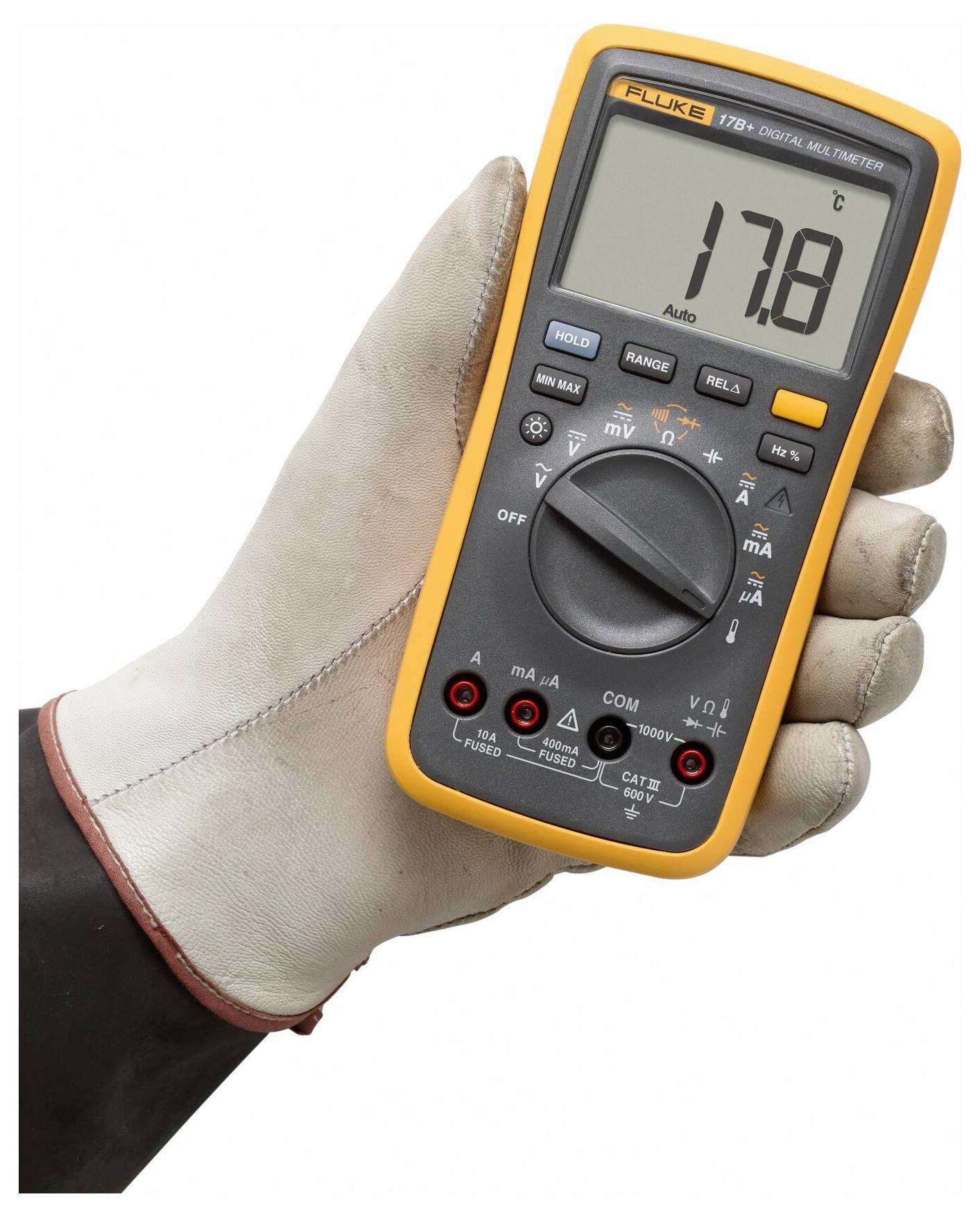 Eine Hand in einem Handschuh hält ein digitales Multimeter, das 17,8 anzeigt. Das Multimeter hat verschiedene Einstellungen und eine orangefarbene Schutzabdeckung.