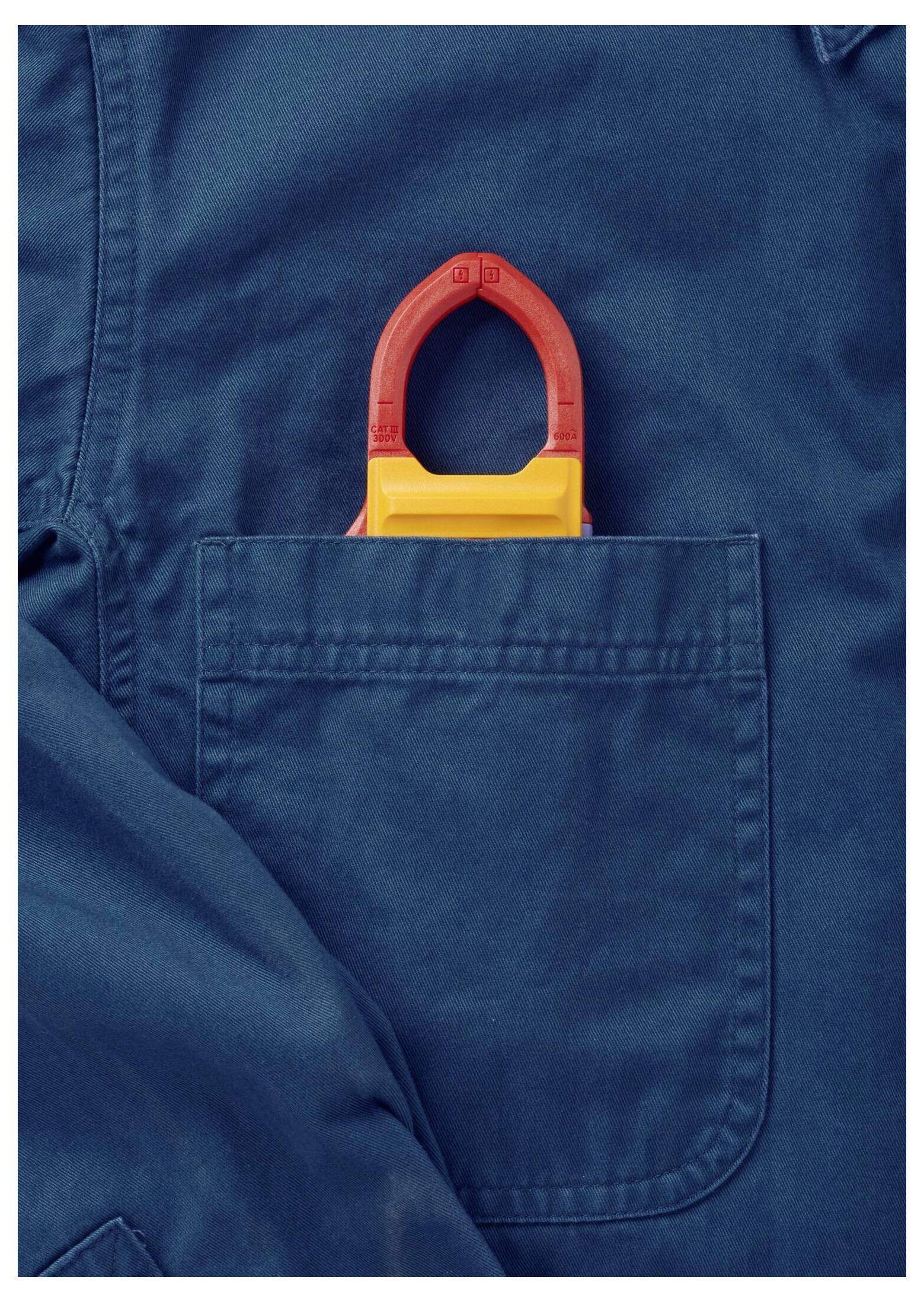 Ein blaues Arbeitshemd mit einem rot-gelben Lockout-Tagout-Gerät, das teilweise aus der Brusttasche hervorlugt und Sicherheitsmaßnahmen andeutet.