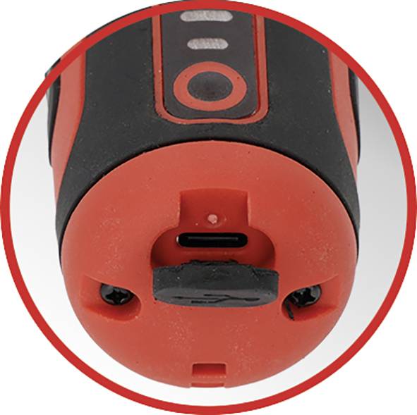 Eine Nahaufnahme eines roten und schwarzen elektronischen Geräts, die einen USB-Ladeanschluss am unteren Rand zeigt, der zur Hervorhebung von einem roten Kreis umrandet ist.