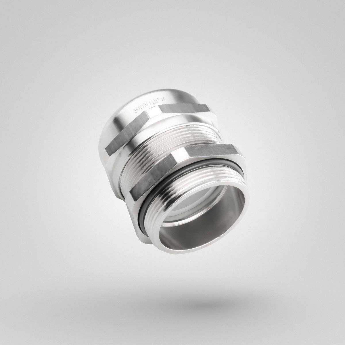 Ein metallischer Verbinder mit Gewindedesign schwebt vor einem neutralen grauen Hintergrund und betont sein industrielles Aussehen und seine glatte Oberfläche.