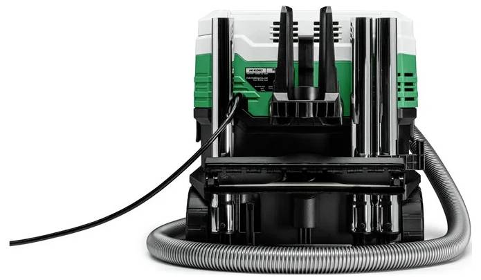 Eine grüne und schwarze Industriemaschine mit angeschlossenen Kabeln und Schläuchen, von vorne gesehen, vor einem weißen Hintergrund.