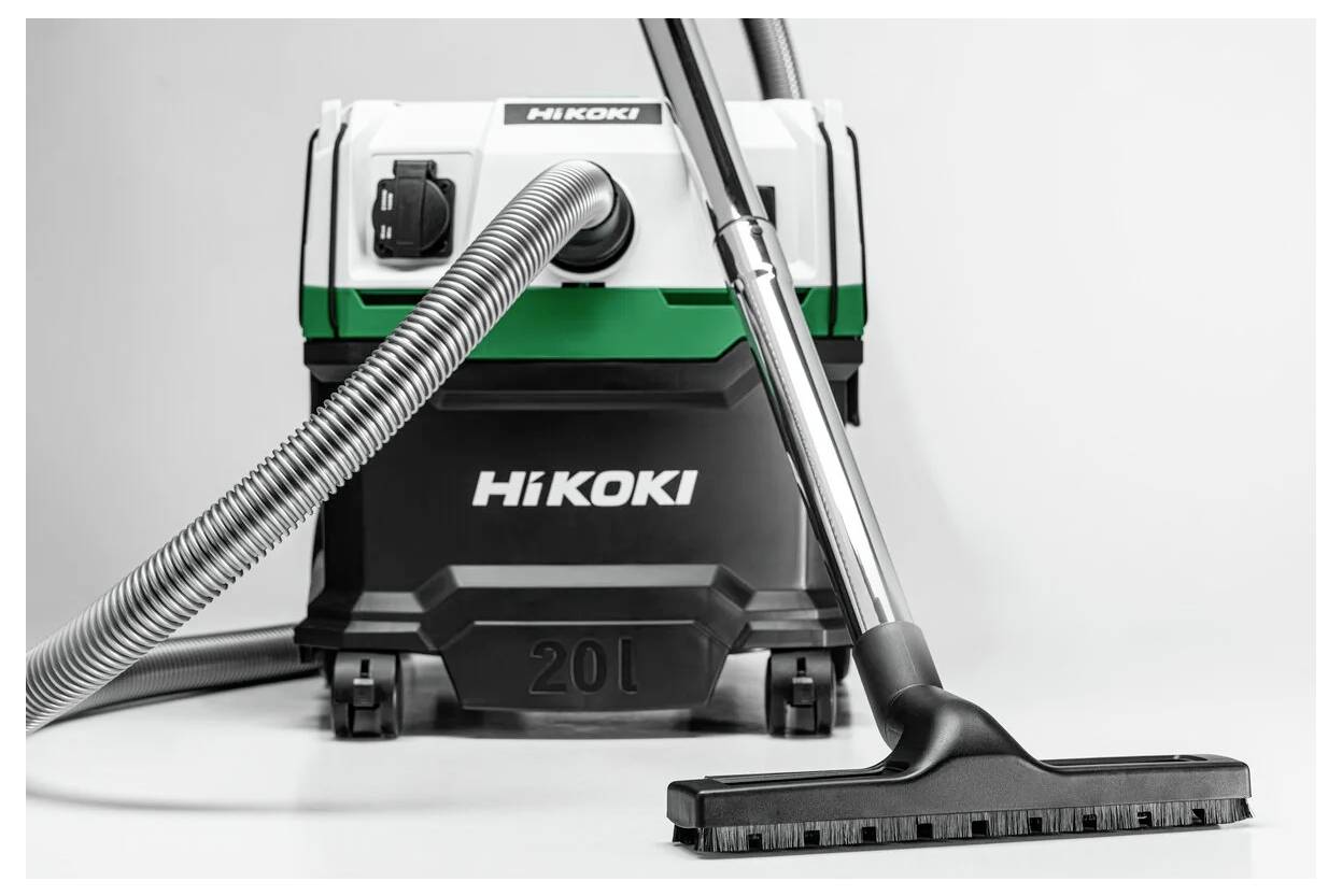 Ein schwarz-weißer Staubsauger mit Schlauch und Bürstenaufsatz, mit der Marke 'Hikoki' versehen, wird präsentiert, wobei seine 20-Liter-Kapazität hervorgehoben wird.