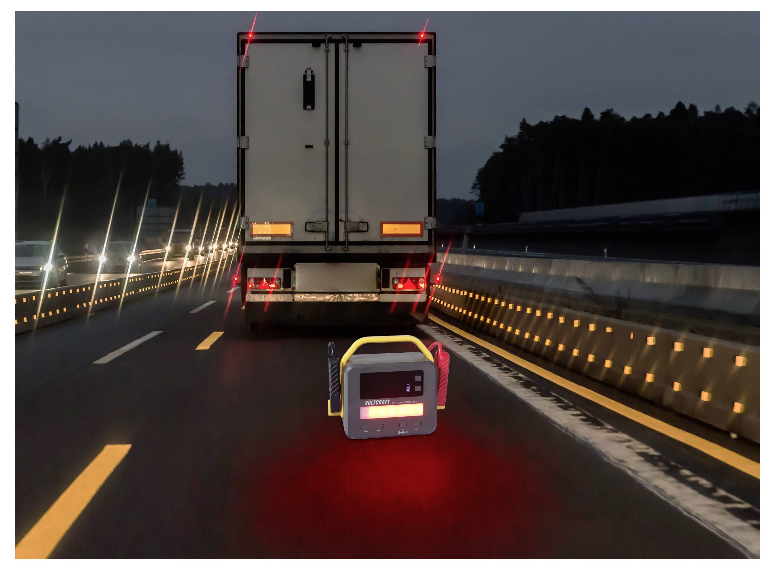 Ein tragbares Straßensicherheitsgerät sendet ein rotes Lichtsignal hinter einem Lastkraftwagen auf einer Autobahn in der Dämmerung aus und verbessert die Sichtbarkeit sowie die Warnung für vorbeifahrende Fahrzeuge.