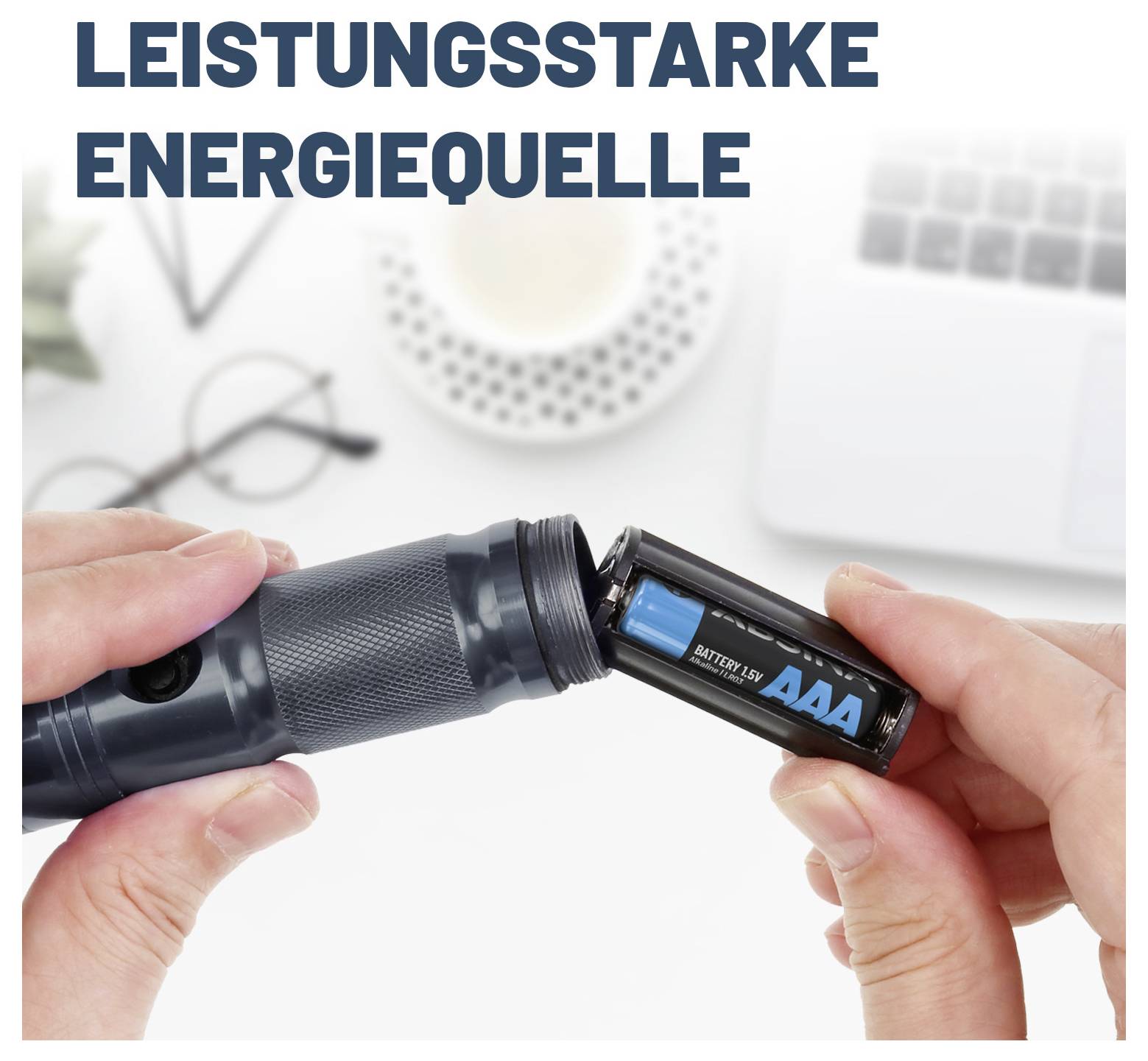Eine Person legt AAA-Batterien in eine Taschenlampe ein, mit dem deutschen Text „LEISTUNGSSTARKE ENERGIEQUELLE