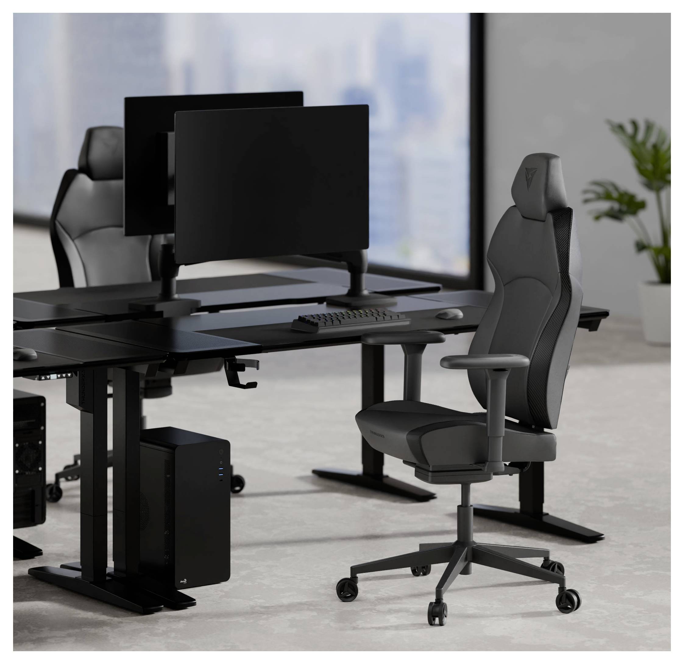 Zwei moderne schwarze Büroschreibtische mit Doppelmonitoren, einer Tastatur und ergonomischen Stühlen in einem hellen Raum mit Blick auf eine Stadtlandschaft.