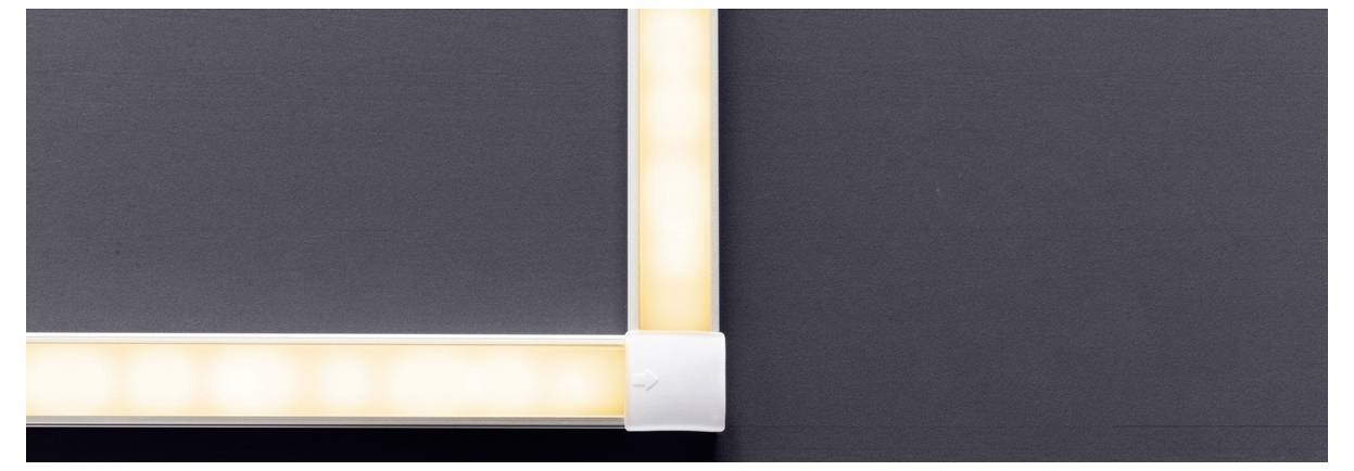 Eine Nahaufnahme einer Ecke eines Hintergrundbeleuchteten Rahmens vor dunklem Hintergrund, die die beleuchteten Kanten und das elegante Design zeigt.