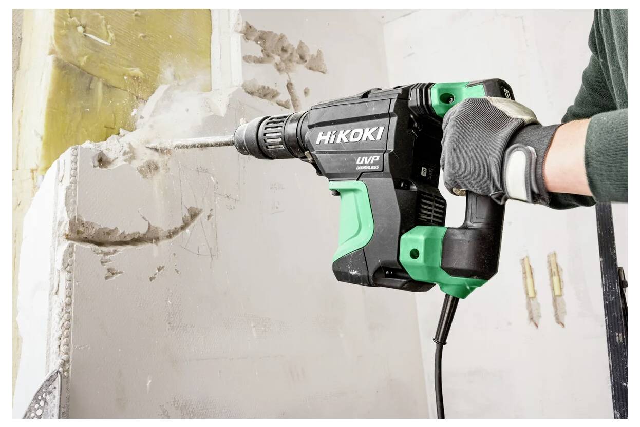 Eine Person verwendet einen HiKOKI-Bohrhammer, um Beton zu brechen und zeigt damit die Kraft und Effektivität des Werkzeugs bei Bauarbeiten.