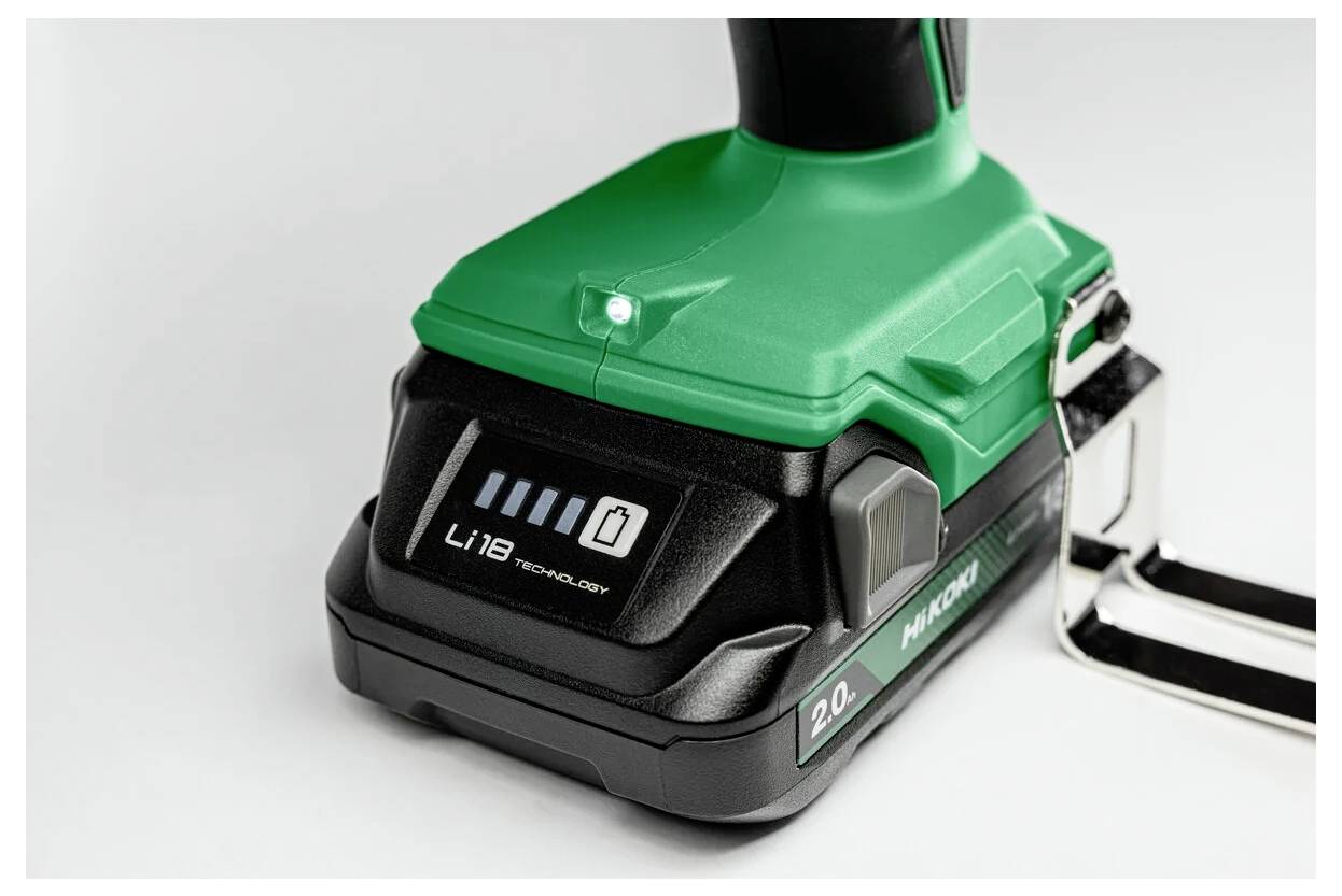 Eine Nahaufnahme des Akkupacks eines grün-schwarzen kabellosen Werkzeugs, die Akkustandsanzeige-Leuchten und ein Etikett mit der Aufschrift „Li 18 Technologie