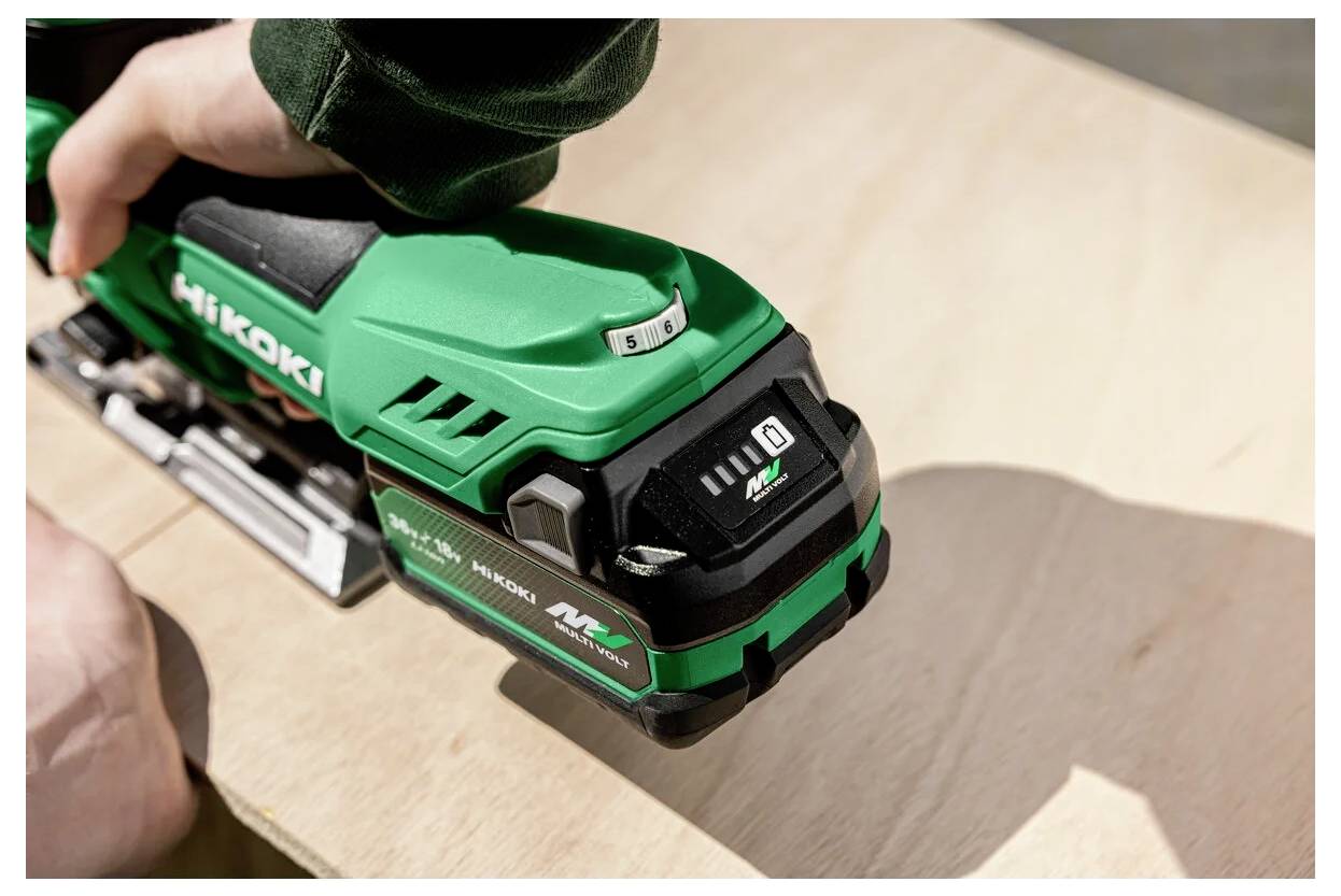 Ein grünes und schwarzes tragbares Elektrowerkzeug wird auf einer Holzoberfläche verwendet, wobei Details zur Marke und zu den Einstellungen sichtbar sind.