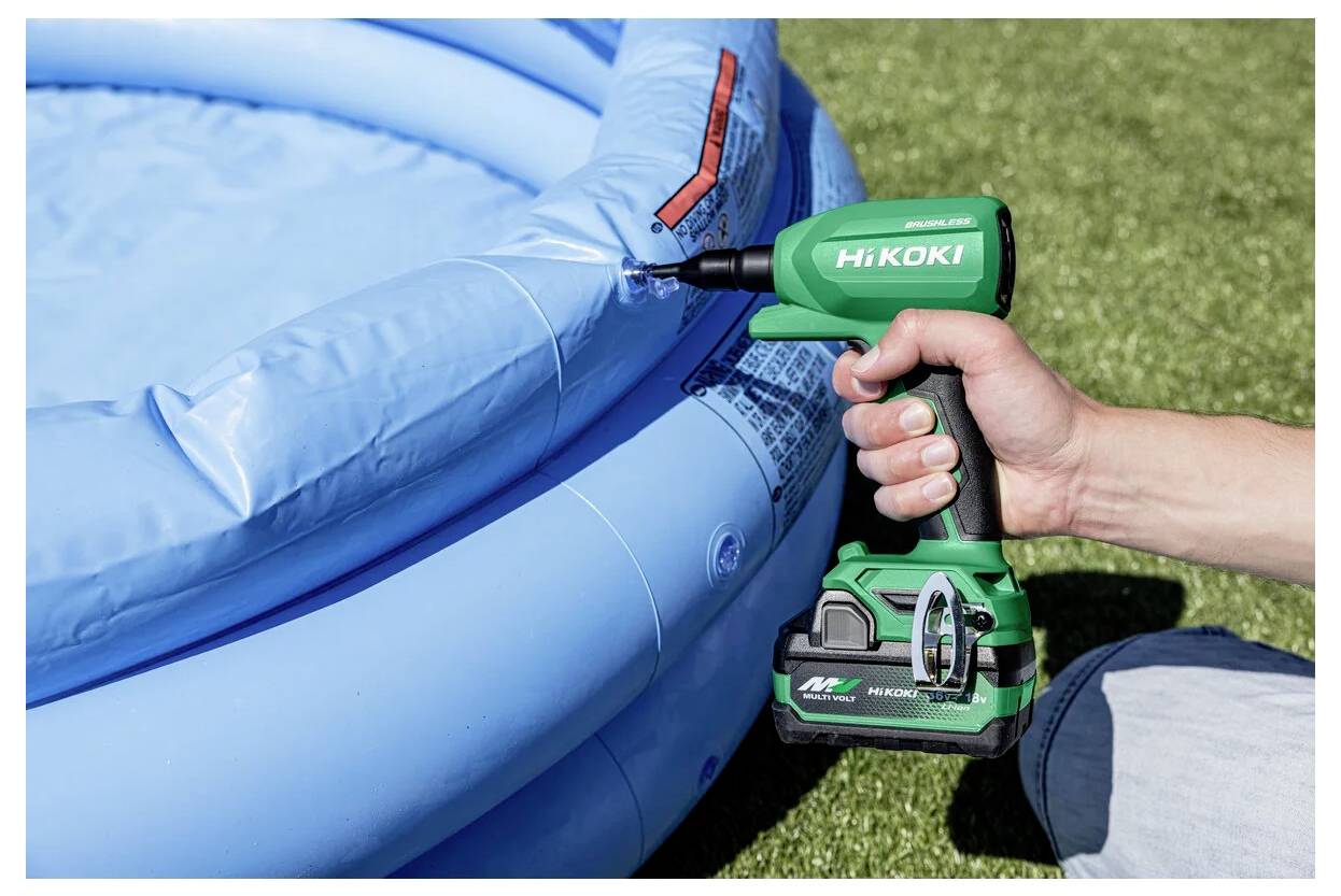 Eine Person verwendet einen grünen kabellosen HiKoki-Luftverdichter mit integriertem Manometer, um einen blauen Pool auf grasbewachsenem Boden aufzupumpen.
