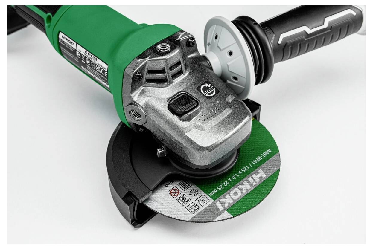 Eine elektrische Winkelschleifer in Grün und Silber, der die Schleifscheibe und den Griff zeigt.