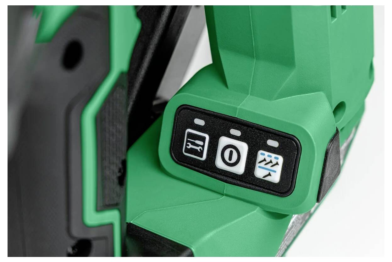 Nahaufnahme eines grünen Werkzeugbedienfelds mit drei Tasten: ein Bild einer Sägeblattklinge, eine Scheibe mit einem Schrägstrich durchkreuzt und stilisierte Wellen.