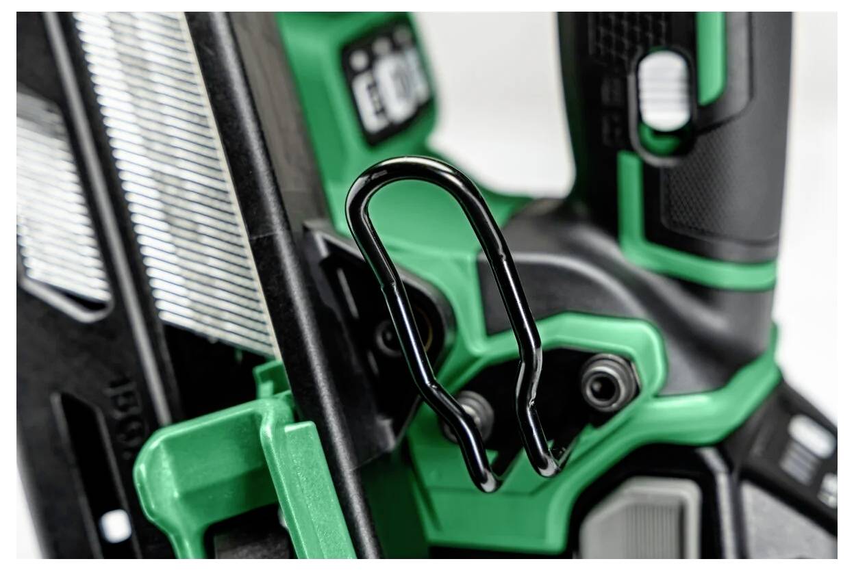 Nahaufnahme eines grünen und schwarzen Elektrowerkzeugs mit einem metallischen Sicherheitshaken, der einen Teil des Griffs und die strukturierten Oberflächen zeigt.