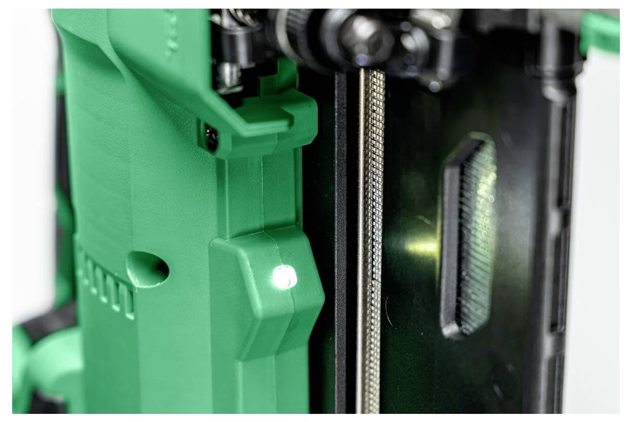 Eine Nahaufnahme eines grün-schwarzen Maschinenteils, die strukturierte Oberflächen und komplexe mechanische Details zeigt und das industrielle Design hervorhebt.