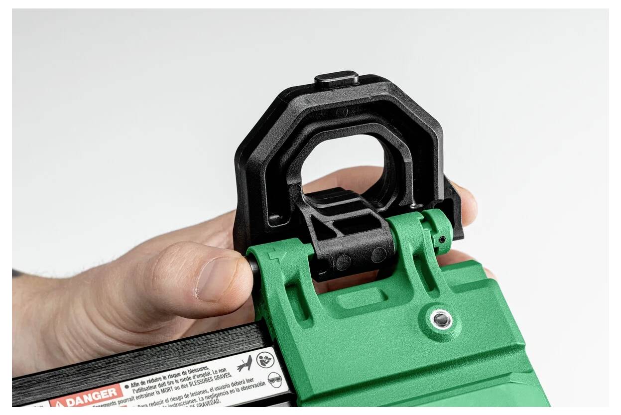 Eine Hand, die ein grünes Gerät mit einem schwarzen verstellbaren Verschluss hält, was auf einen Mechanismus zum Verriegeln oder Sichern eines Objekts hinweist.