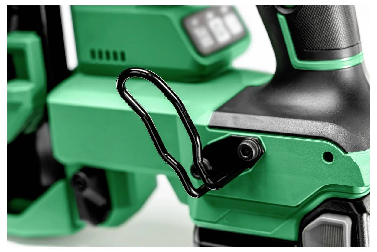 Nahaufnahme eines grünen und schwarzen Elektrowerkzeugs, das eine metallische Schlaufe für das Aufhängen oder Tragen besitzt. Das Werkzeug wirkt modern und robust.