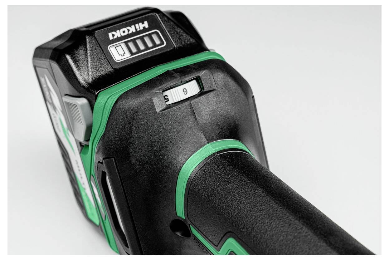 Eine Nahaufnahme einer schwarzen und grünen Akku-Werkzeugbatterie mit einem Schiebeschalter, der die Modi 'S' und 'H' anzeigt, und einem Batteriestandsanzeiger auf der Oberseite.