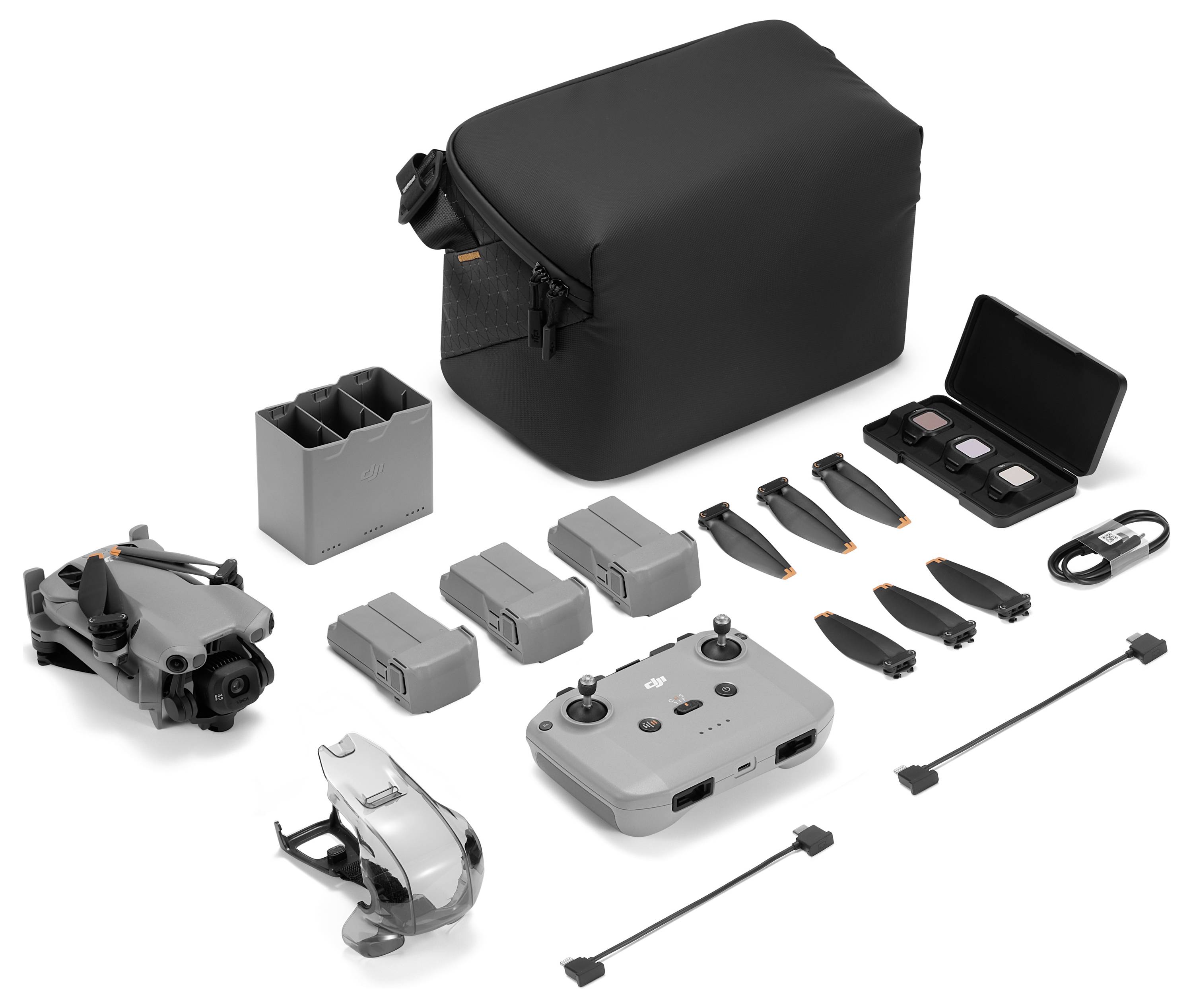 Drohnen-Set ausgestellt: umfasst eine Drohne, drei Akkus, eine Fernbedienung, zusätzliche Propeller, einen Ladehub, Kabel und eine schwarze Tragetasche.