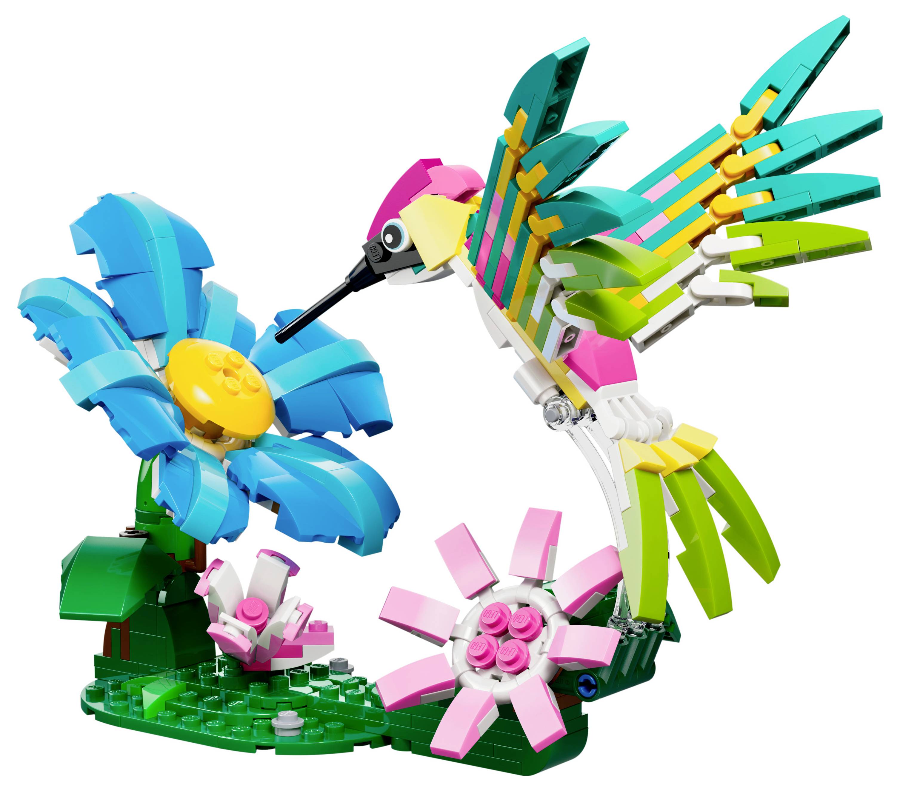 Ein farbenfrohes LEGO-Modell, das einen Kolibri in Rosa-, Grün- und Gelbtönen zeigt, wie er Nektar aus einer blauen Blume mit gelbem Zentrum trinkt.