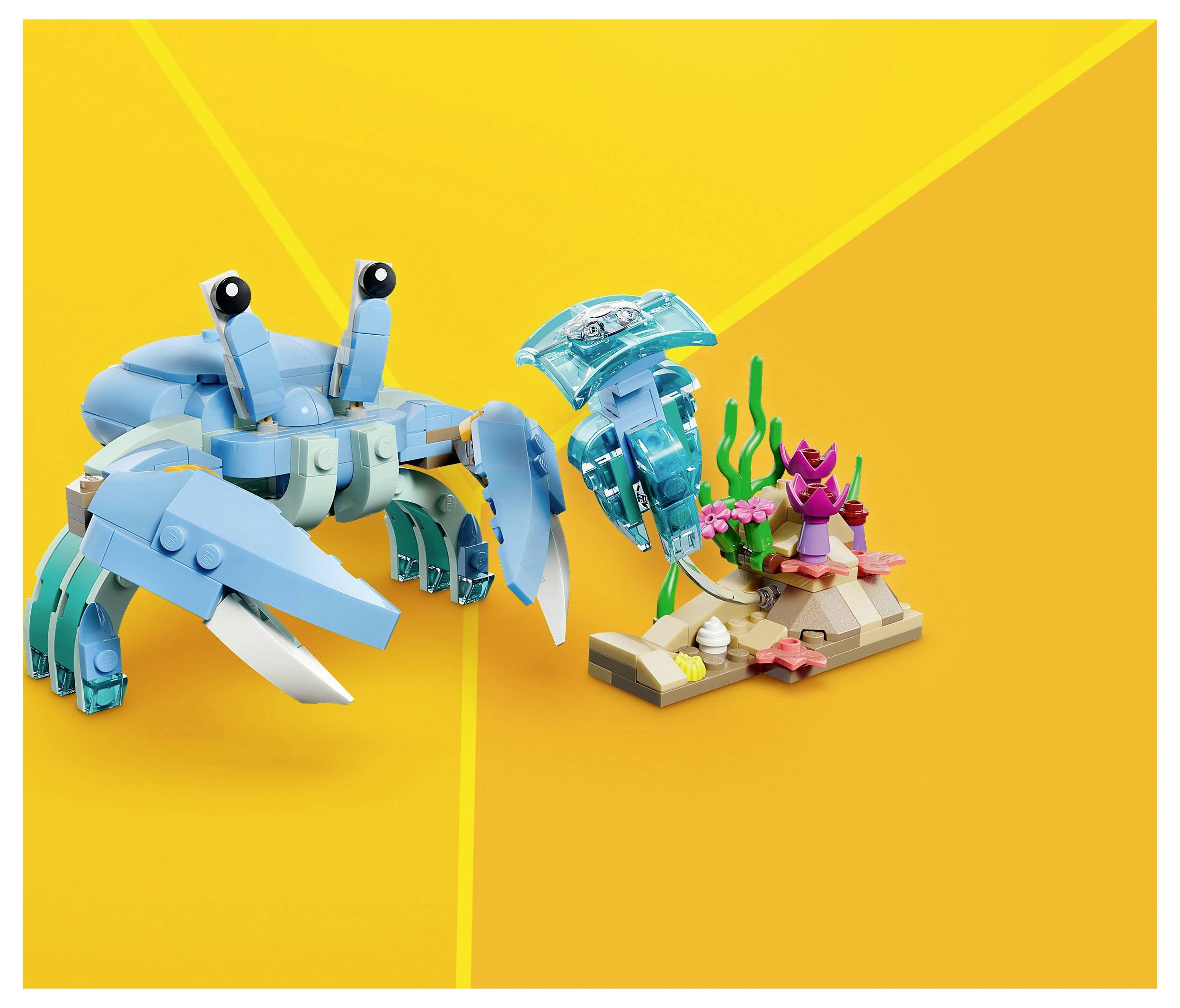 Eine blaue Krabbe und ein Hummer aus Bauklötzen stehen auf einer kleinen meeresbezogenen Basis mit Korallen und Seetang vor einem orangefarbenen Hintergrund.