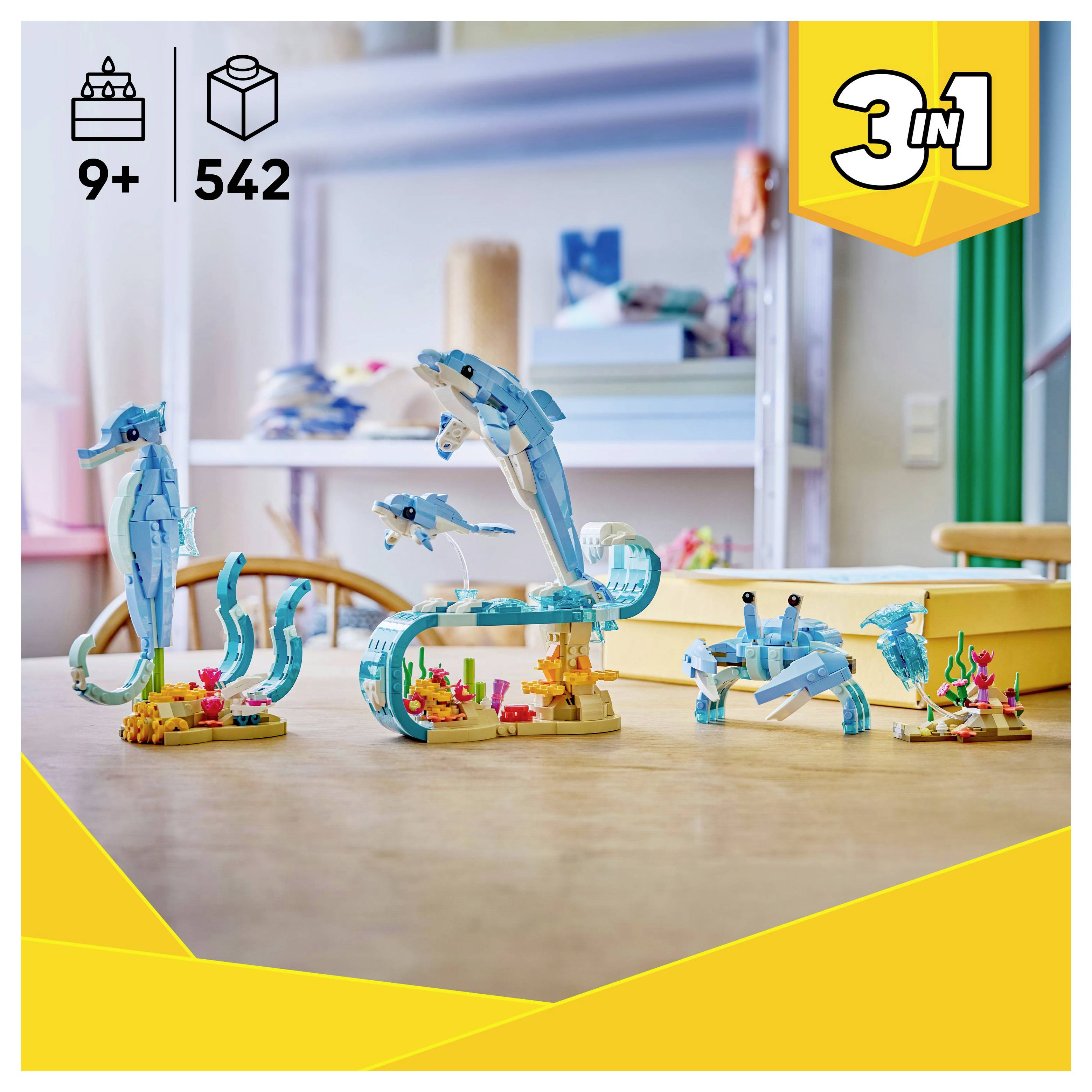 Spielbaukasten auf einem Tisch mit drei Meeresbewohnern: einem Delfin, einem Seepferdchen und einer Krabbe. Beschriftet mit '3 in 1', Altersempfehlung 9+ und 542 Teilen.
