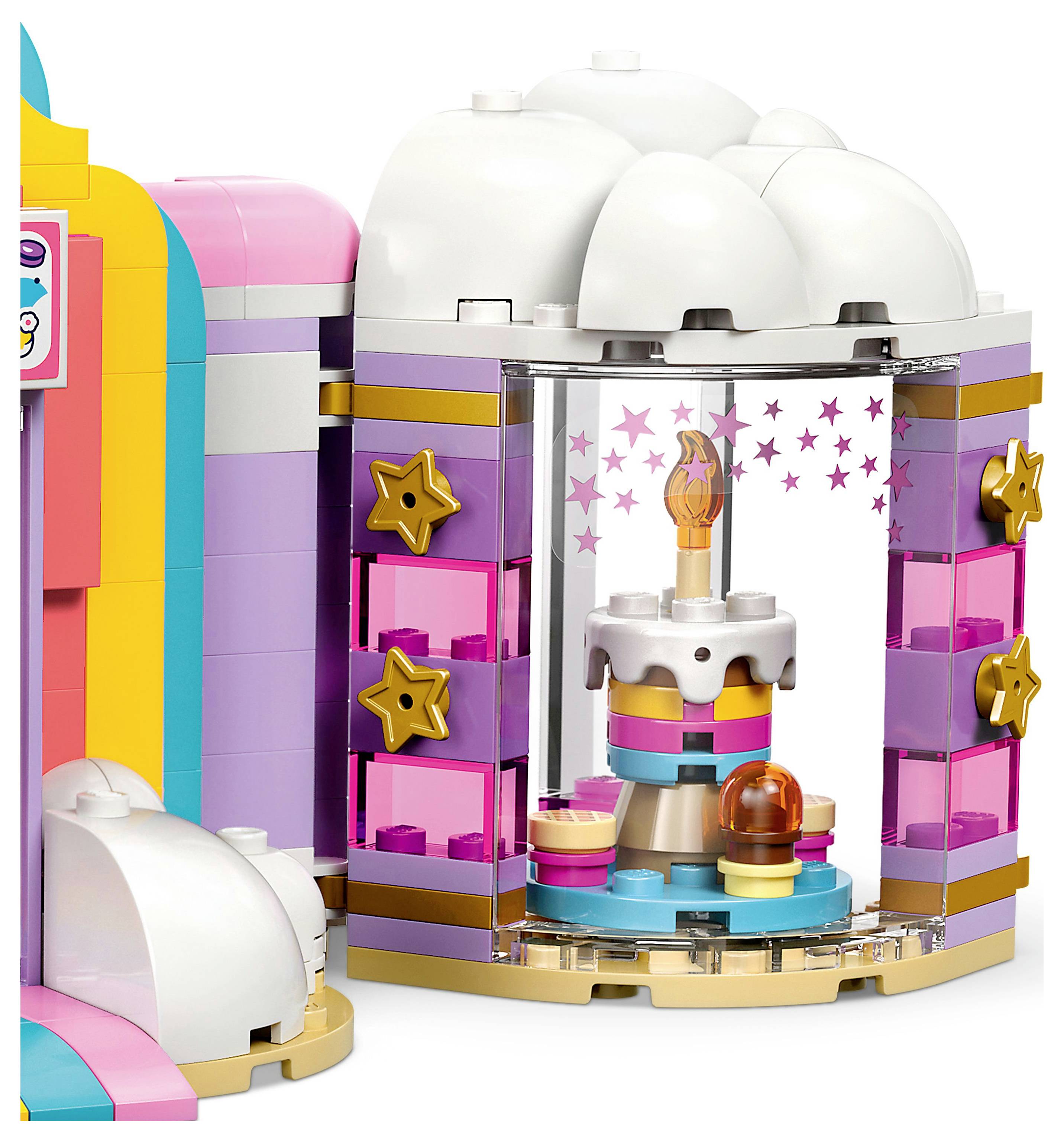 Ein Spielzeug-Bausatz mit einer bunten Bäckerei, die ein Schaufenster besitzt. Im Inneren befindet sich eine mehrstöckige Torte und ein Cupcake auf einem Ständer.