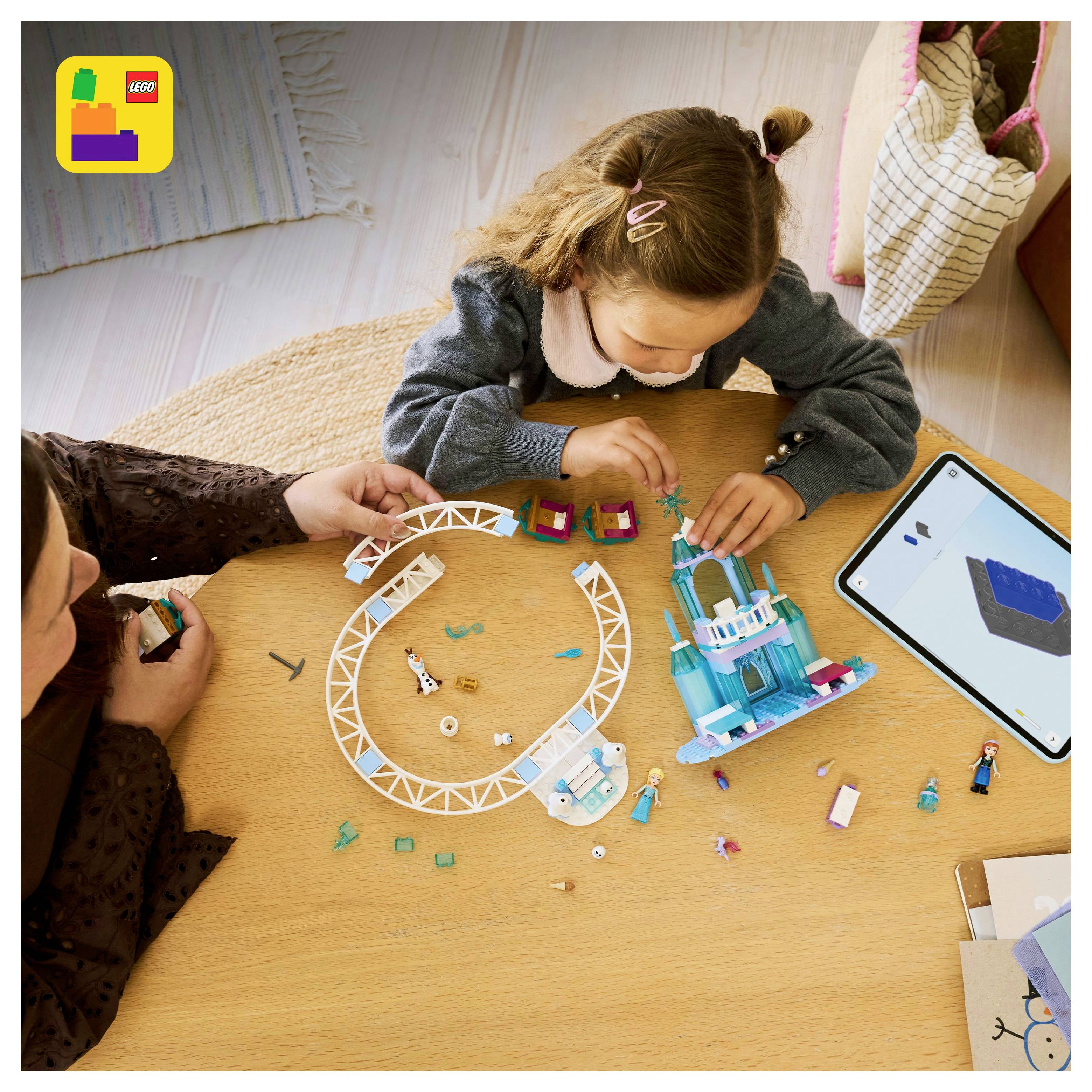 Ein Kind und ein Erwachsener arbeiten gemeinsam daran, ein LEGO-Set auf einem Tisch zu bauen, während in der Nähe ein Tablet mit Bauanleitungen angezeigt wird.