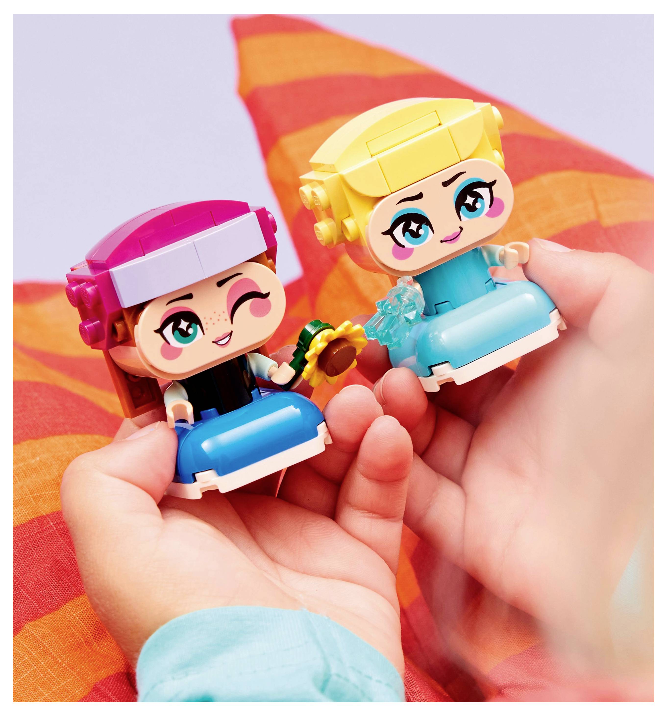 Zwei gezeichnete Plastikspielzeugfiguren, die von Händen gehalten werden, jede mit großen Augen und leuchtenden Farben, vor einem rot gestreiften Hintergrund.