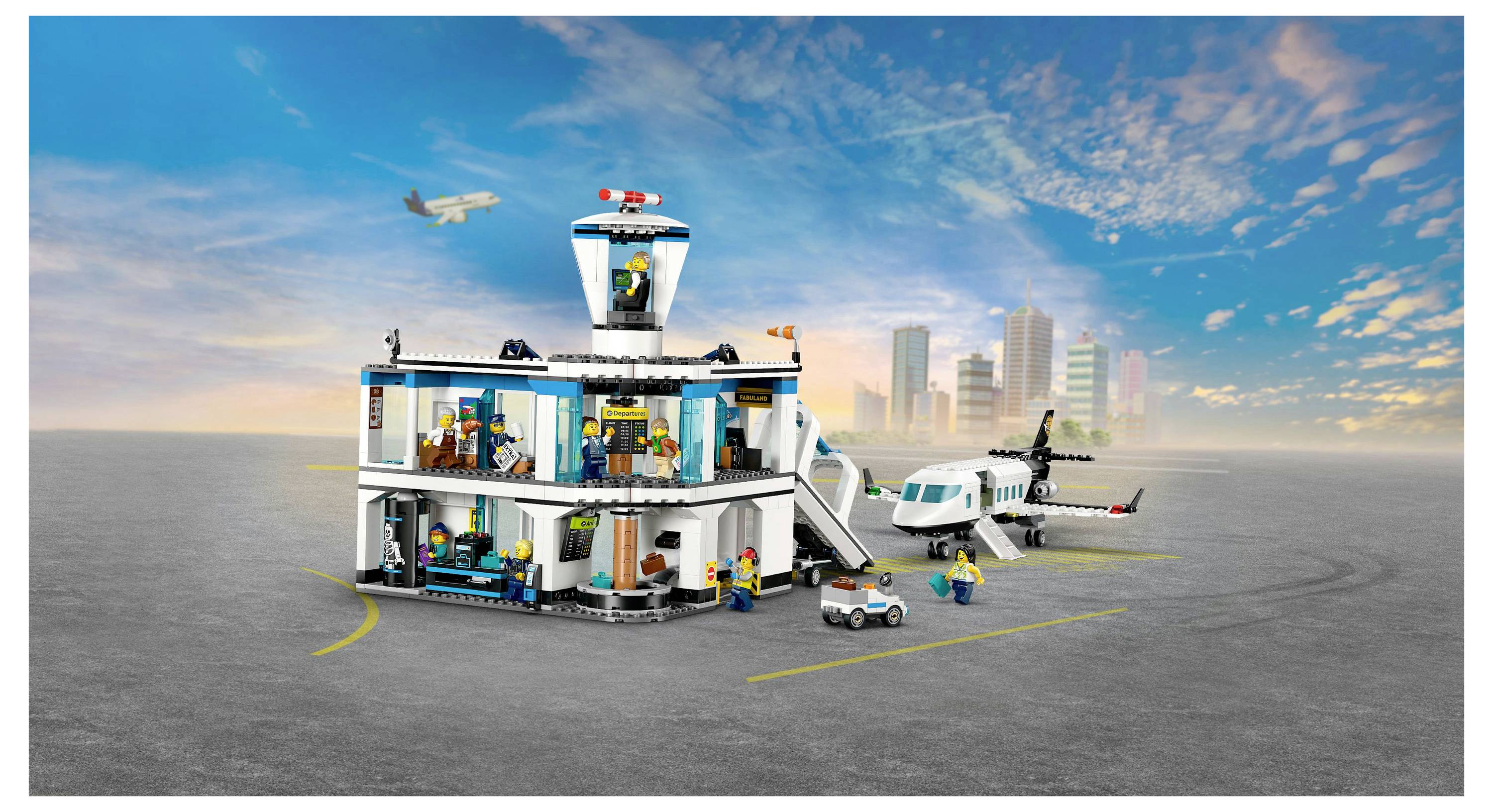 Ein LEGO-Flughafen-Set mit einem Terminal, Kontrollturm, Flugzeug und mehreren Figuren. Die Stadtsilhouette ist im Hintergrund sichtbar.