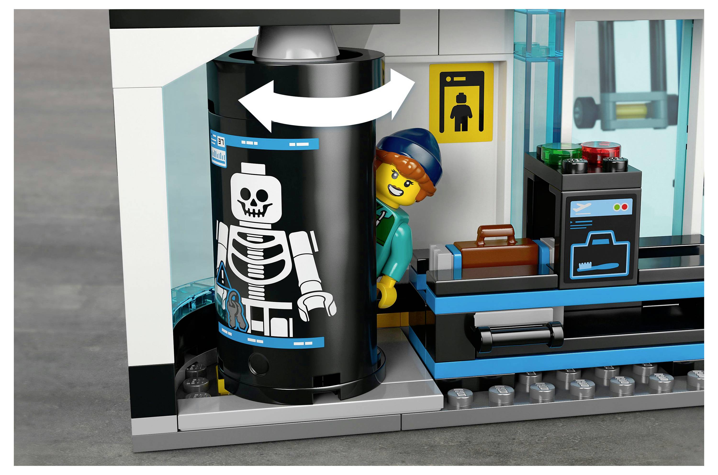 Eine LEGO-Figur mit Helm wird von einer Röntgenmaschine mit Skelettdarstellung gescannt. In der Nähe befindet sich ein Koffer und ein digitaler Bildschirm.