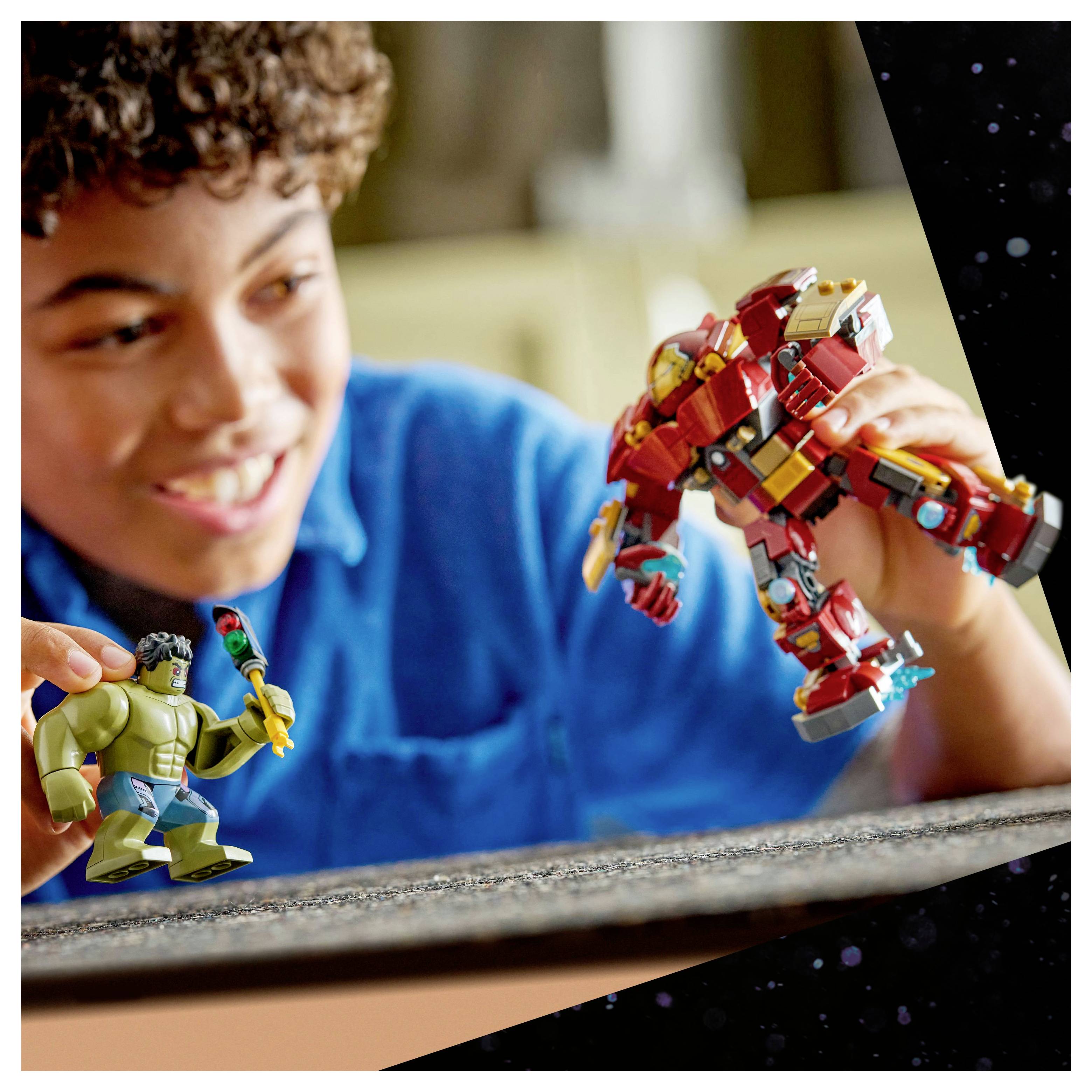 Ein Kind lächelt, während es mit Actionfiguren spielt, wobei eine einen grünen Superhelden und eine andere eine Figur in roter Rüstung darstellt, was auf kreatives Rollenspiel hindeutet.