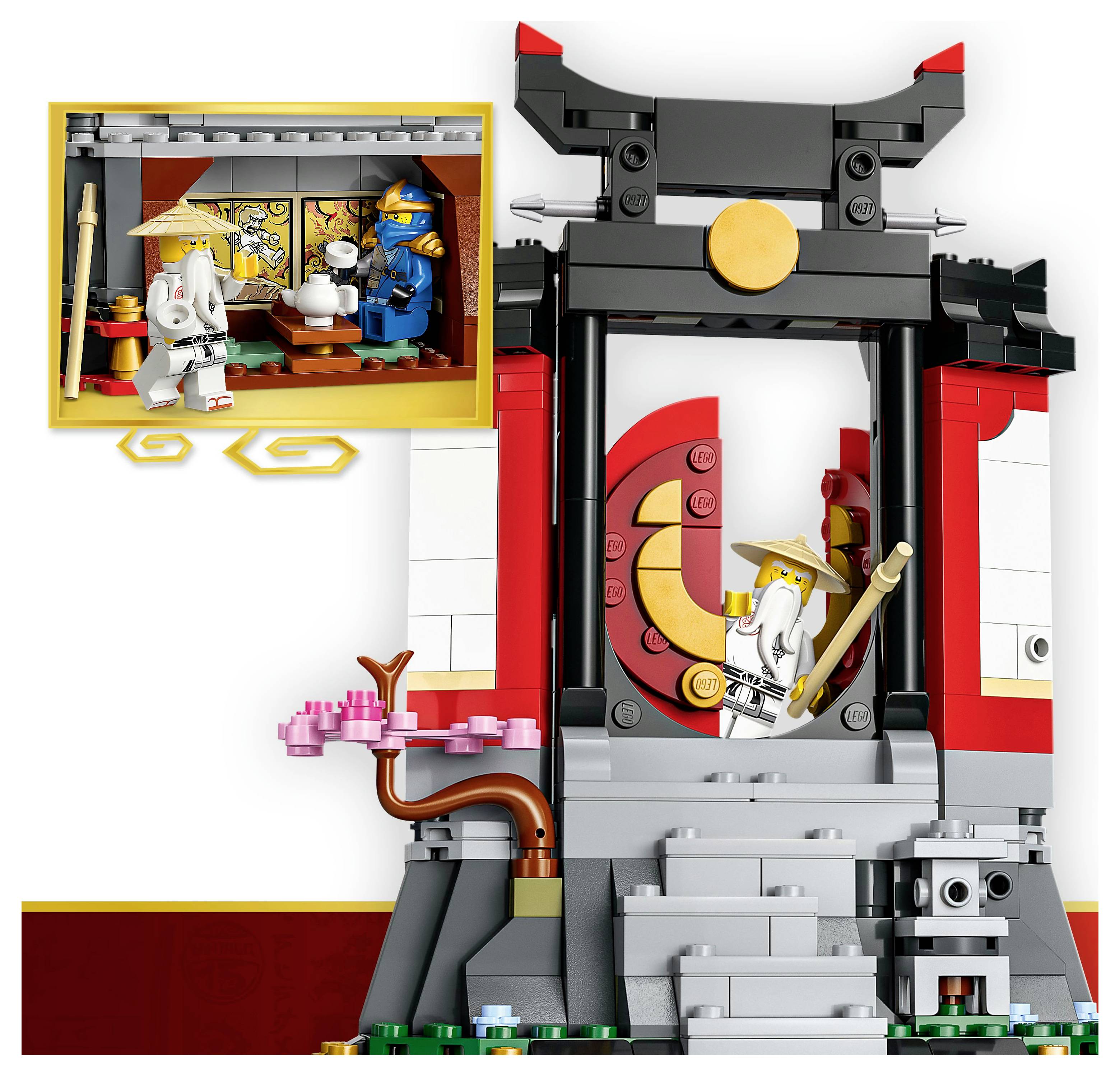 Eine LEGO-Szene zeigt einen Dojo mit zwei Minifiguren - eine in einem weißen Umhang, die einen Stab hält, und eine andere in blauer Rüstung in einem kleineren Innenraum.