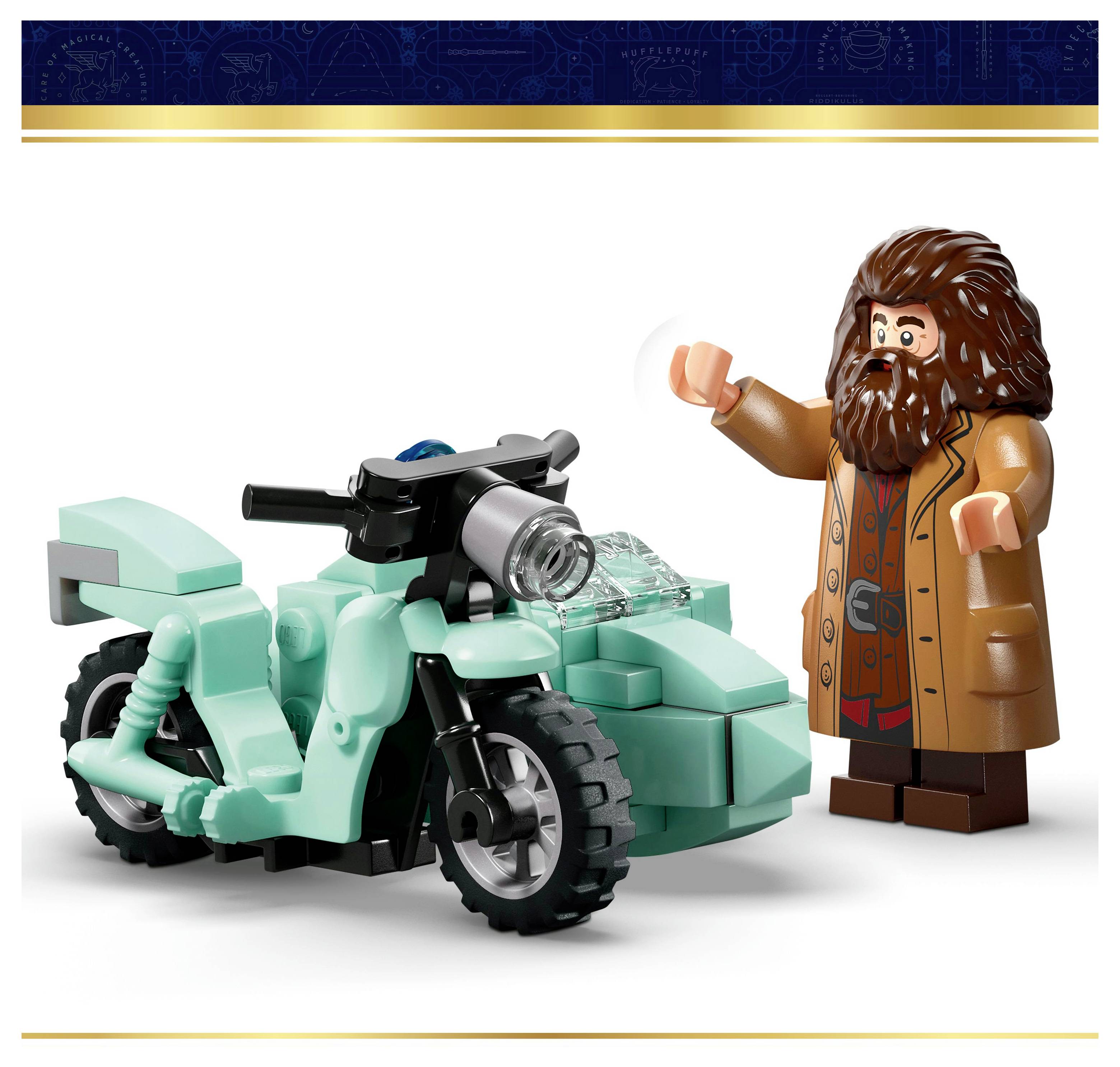 Eine Figur mit langen Haaren und Bart, die einen braunen Mantel trägt, steht neben einem türkisfarbenen Spielzeug-Motorrad und scheint zu winken oder eine Geste zu machen.