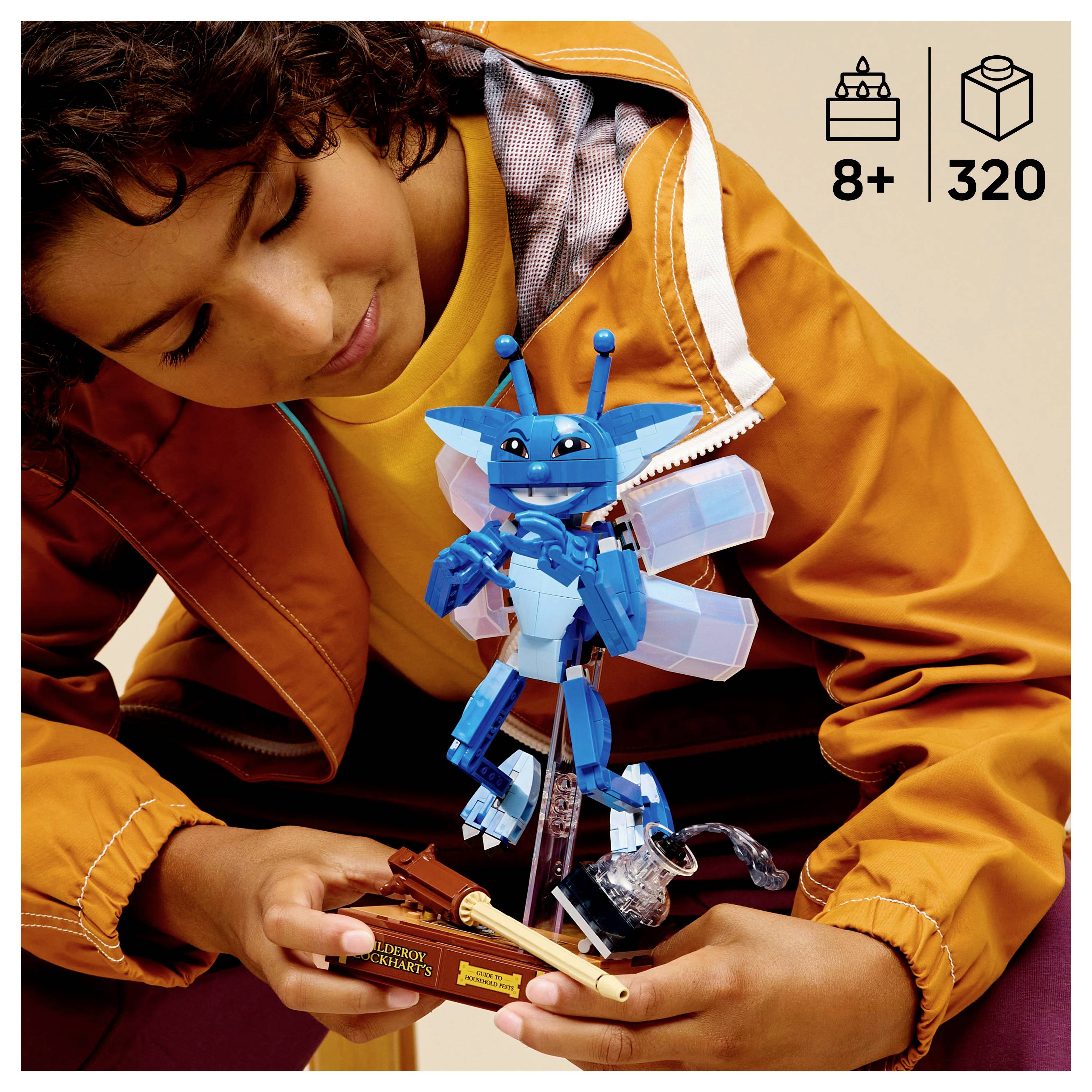 Ein Kind in einer gelben Jacke hält eine blaue Roboturfigur, die aus Bauklötzen zusammengesetzt ist. Die Schachtel gibt eine Altersempfehlung ab 8 Jahren und enthält 320 Teile.