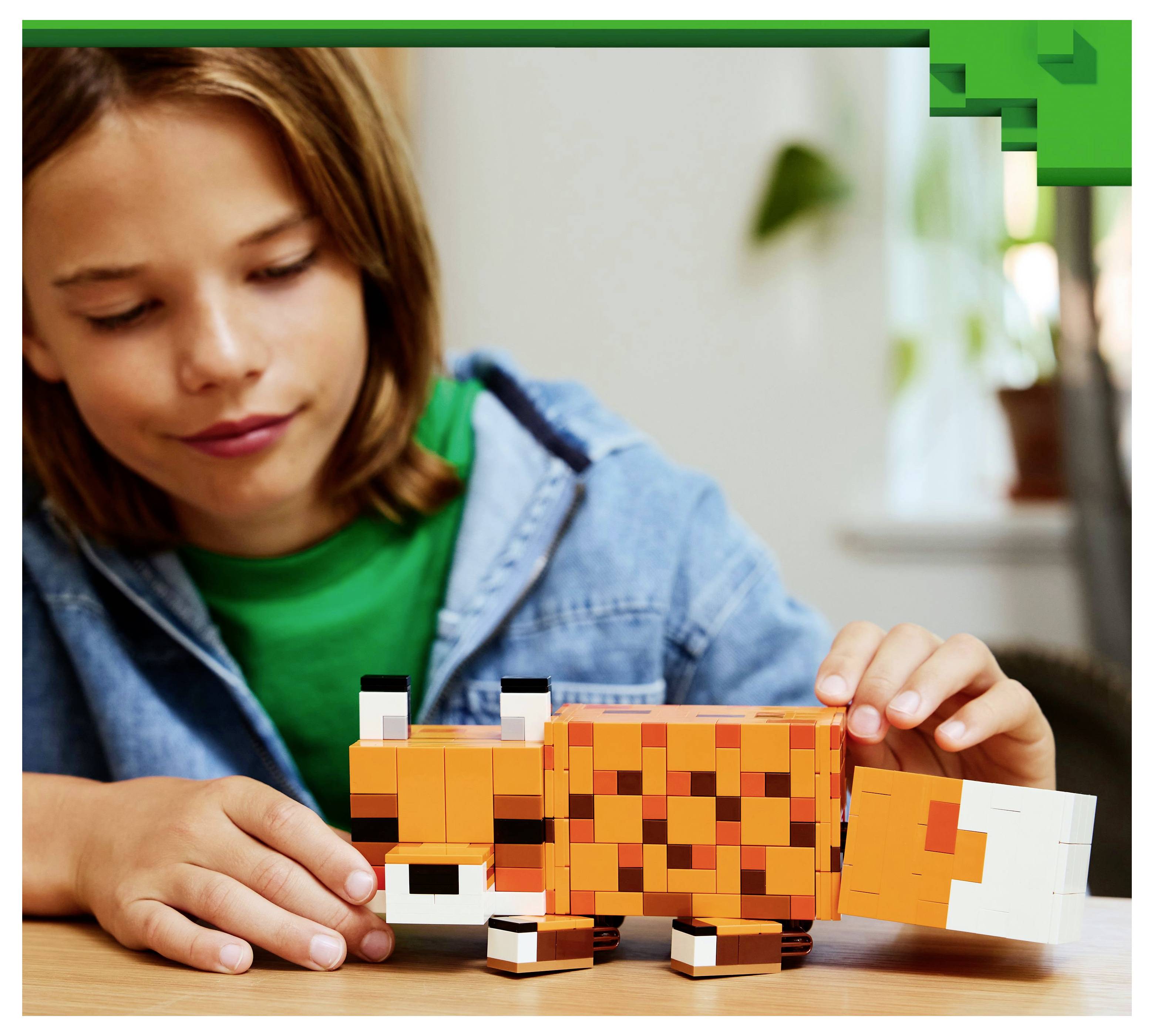 Ein Kind spielt mit einem orange-weißen pixelierten Fuchs-Spielzeug auf einem Tisch und lächelt mit konzentrierter Aufmerksamkeit in einem gemütlichen, hell erleuchteten Raum.