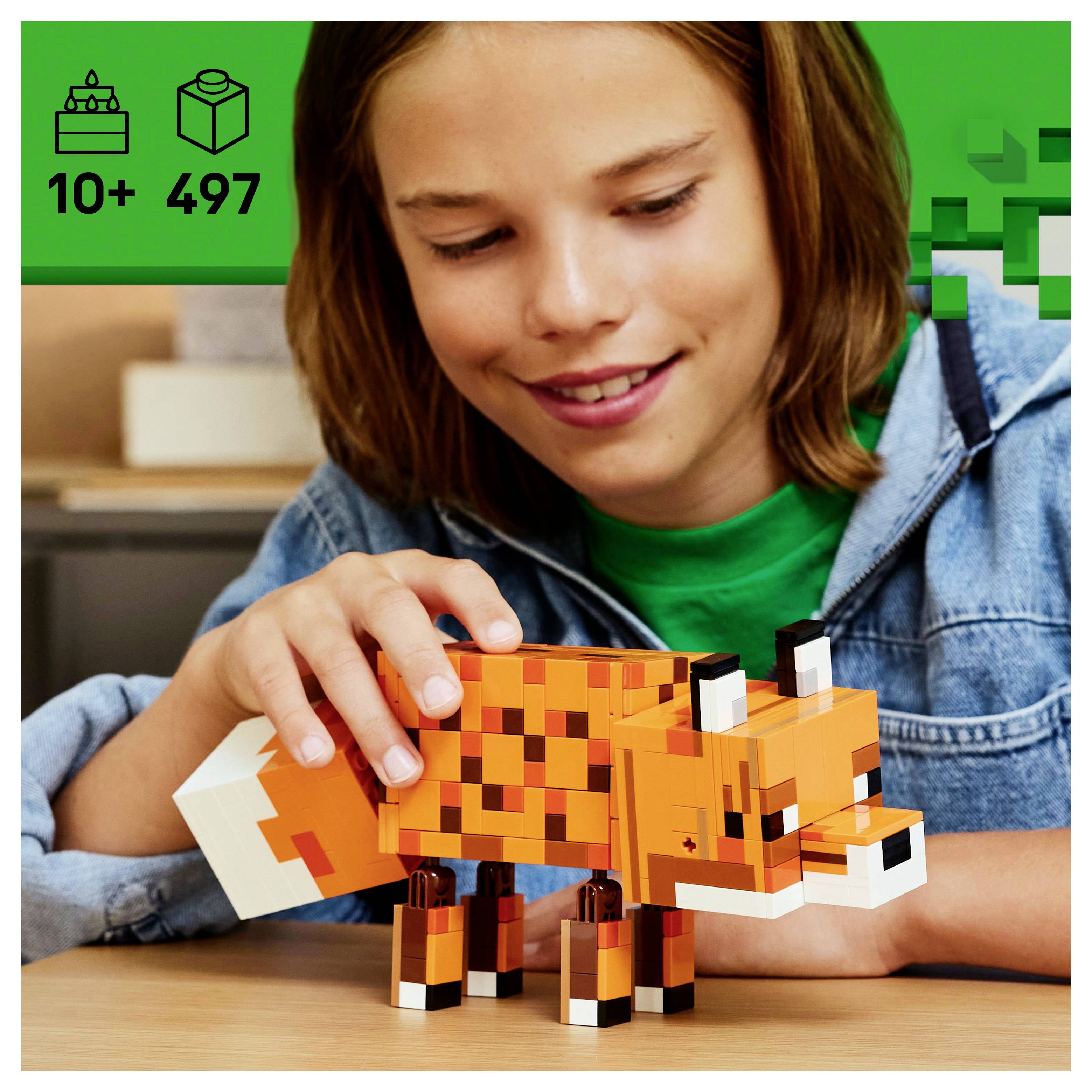 Ein Kind baut ein eckiges, orangefarbenes Fuchsspielzeug. Die Verpackung zeigt '10+ 497', was Alter und Teilezahl angibt. Der Hintergrund zeigt ein grünes Muster.