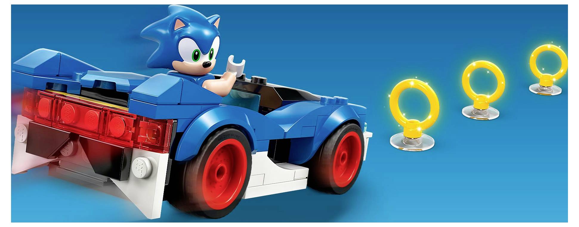 Ein blaues Spielzeugauto mit einer blauen Igelgestalt und leuchtend roten Rücklichtern, zusammen mit drei gelben Ringspielzeugen auf einem blauen Hintergrund.