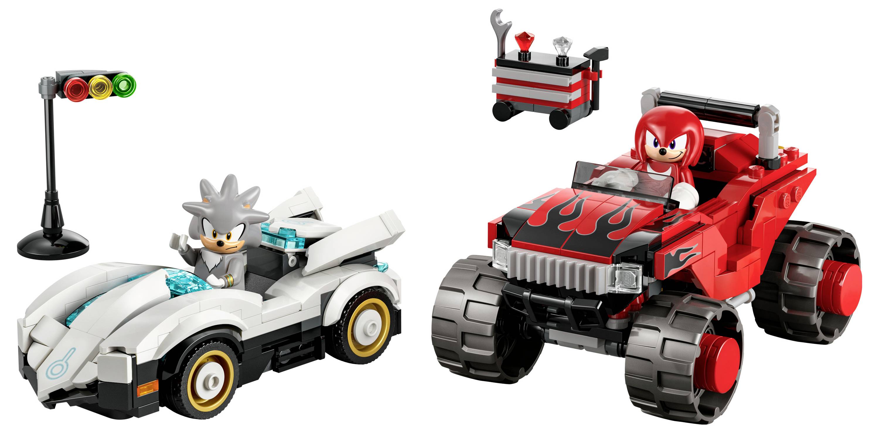 Zwei Spielzeugautos, eines weiß mit einer grauen anthropomorphen Figur, das andere rot mit einer ähnlichen roten Figur. Eine Verkehrsampel und ein Werkzeugwagen in der Nähe.