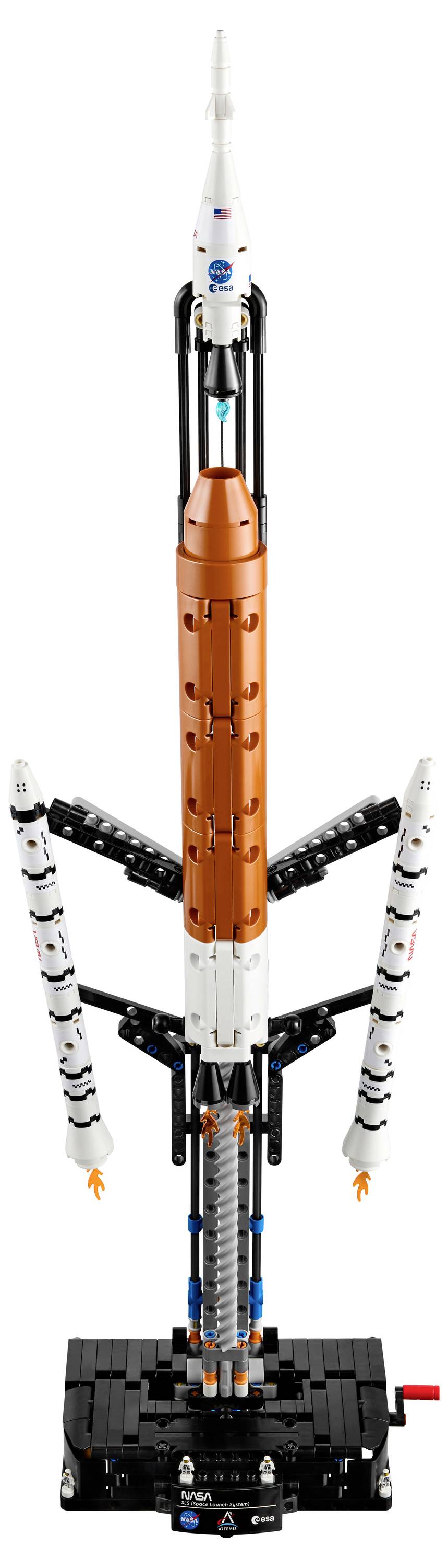Ein Modell einer Rakete mit orangefarbenen und weißen Abschnitten, flankiert von kleineren Boosterraketen, auf einem schwarzen Ständer montiert.