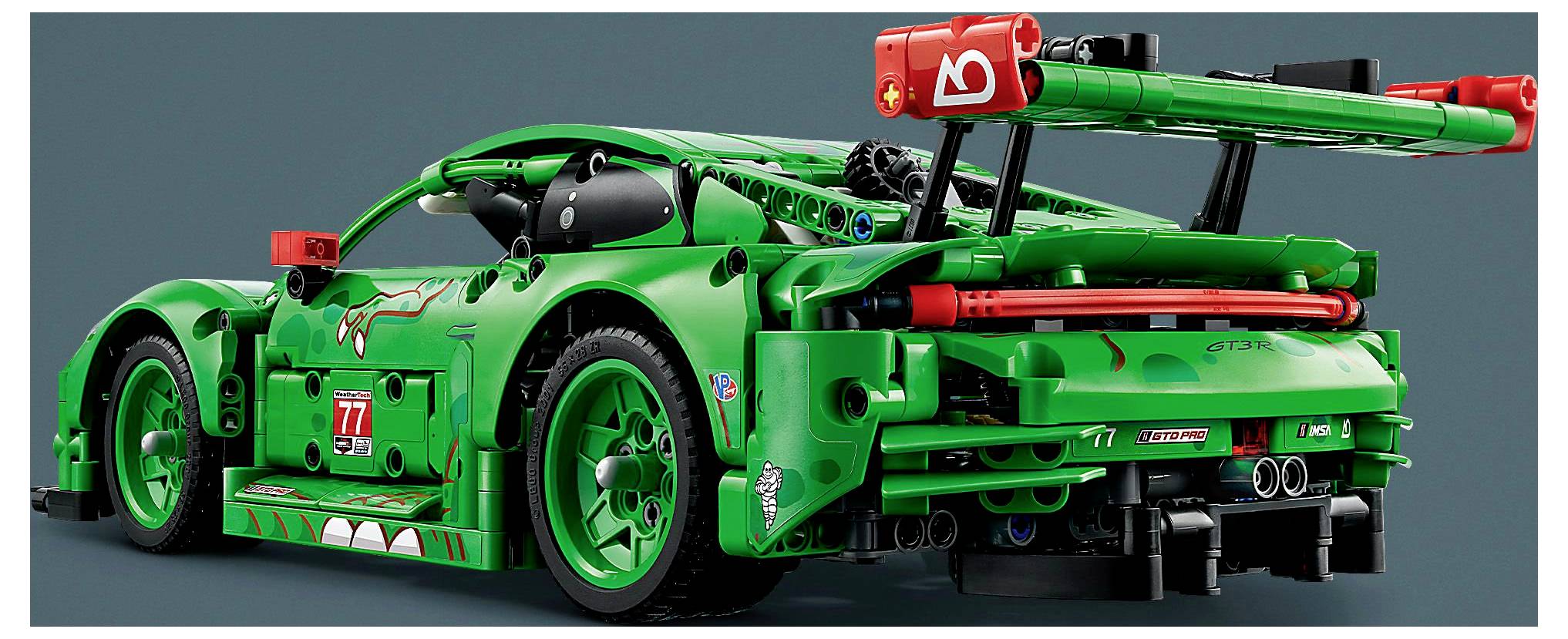 Ein grüner Lego-Rennwagen mit roten Akzenten, großem Heckspoiler und sichtbaren mechanischen Details, der einem leistungsstarken Sportwagen ähnelt.